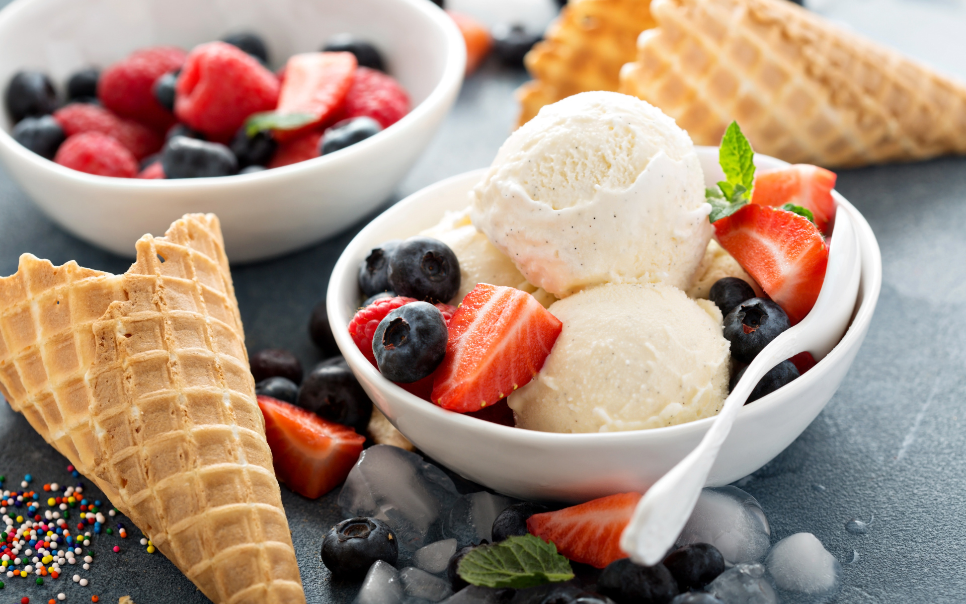 Мороженое с ягодами черники и клубники на столе с вафельными рожками