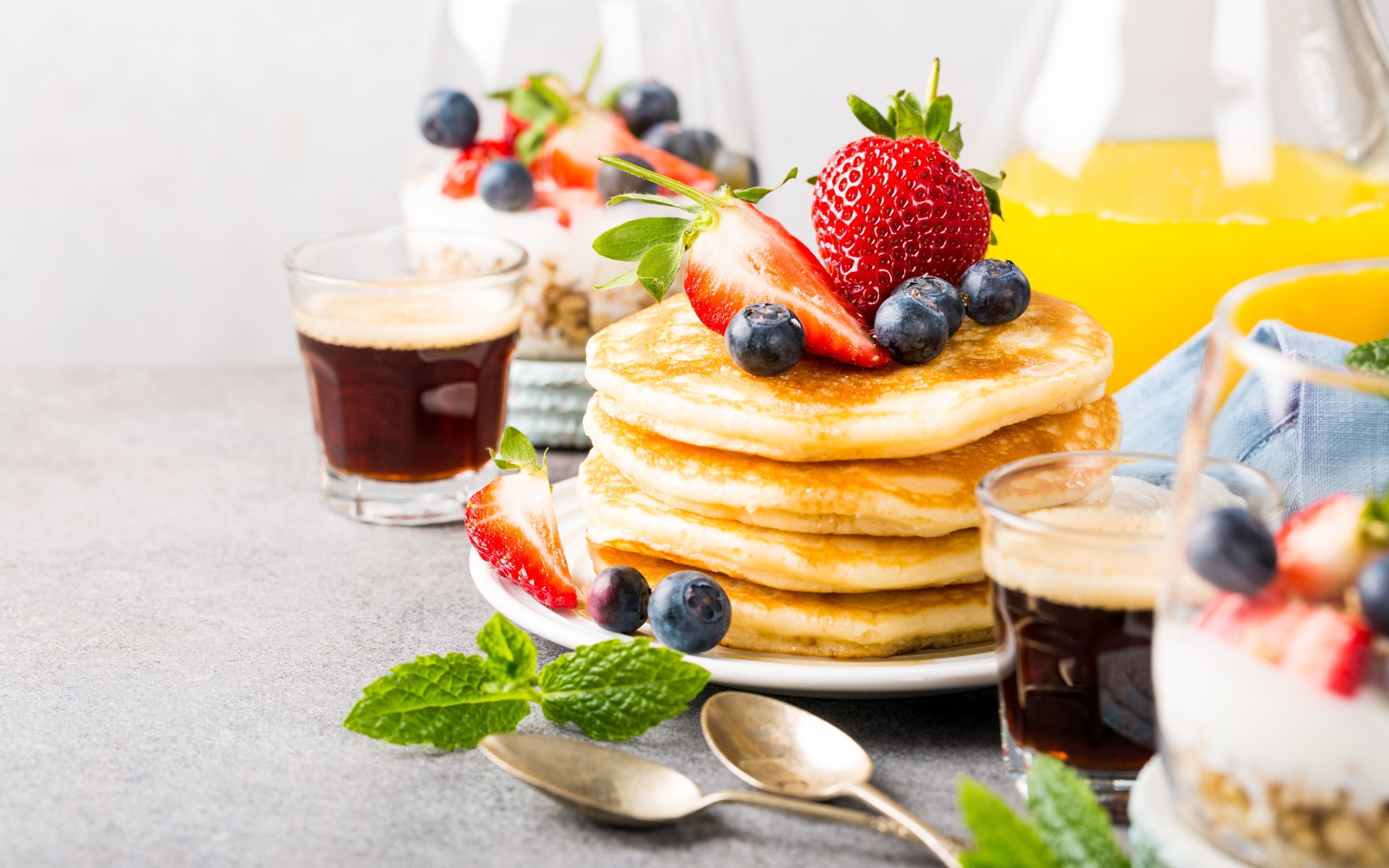 Оладьи с ягодами на столе с соком