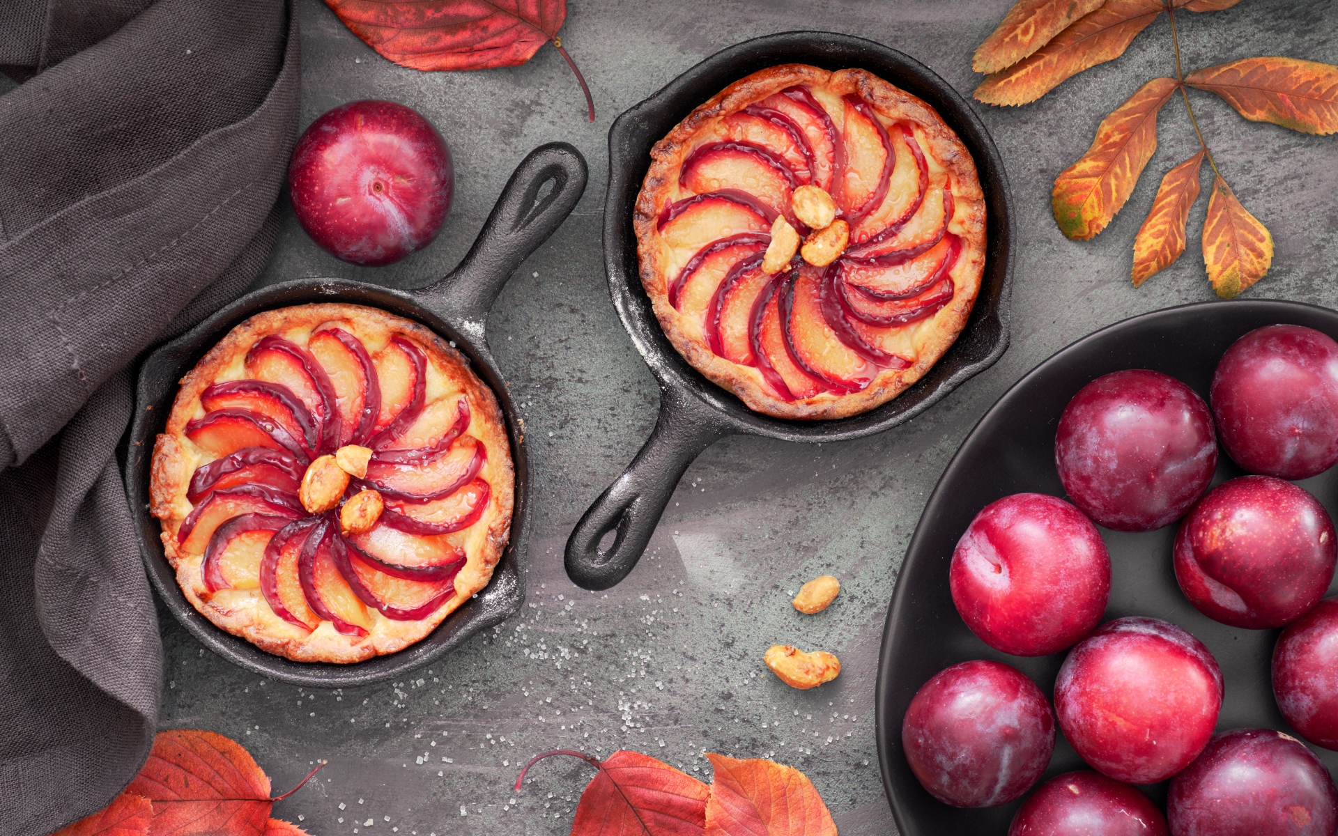 Пирог на столе с розовыми крупными сливами