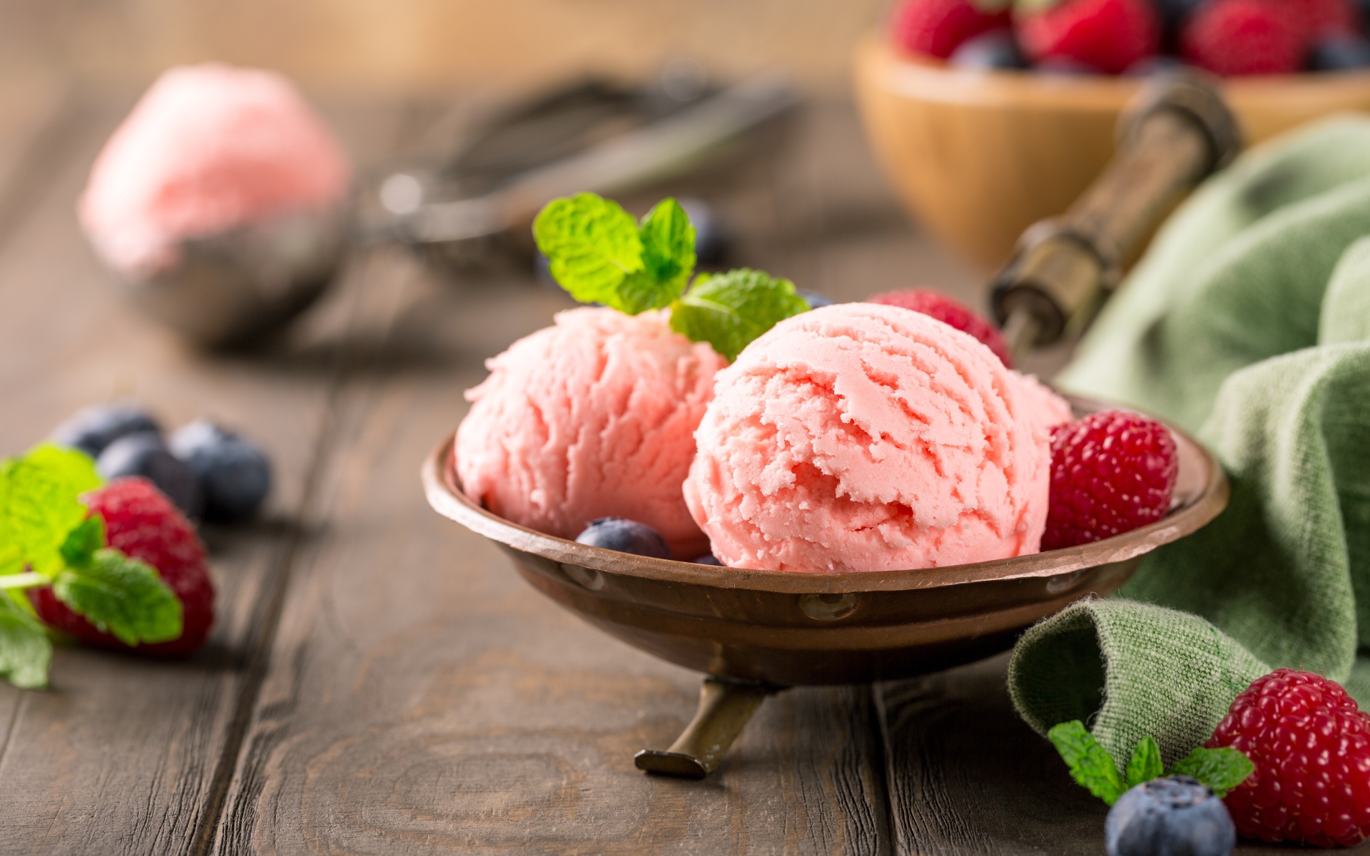 Шарики фруктового мороженого на столе с ягодами малины и черники 