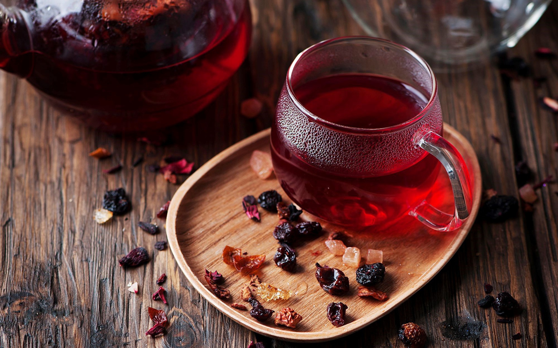 Стеклянная чашка горячего красного чая с сухофруктами 