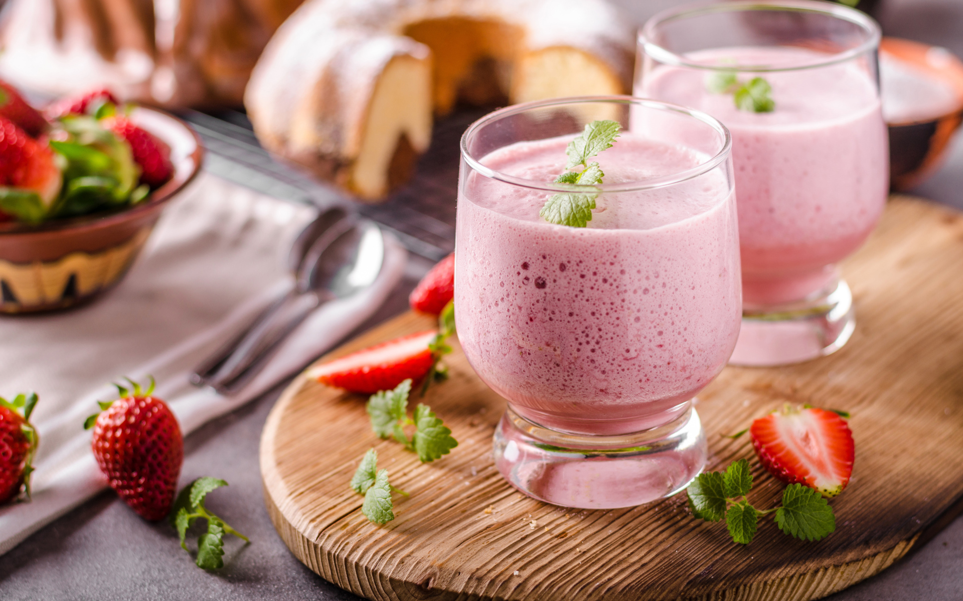 Ягодное смузи в стаканах на столе с клубникой