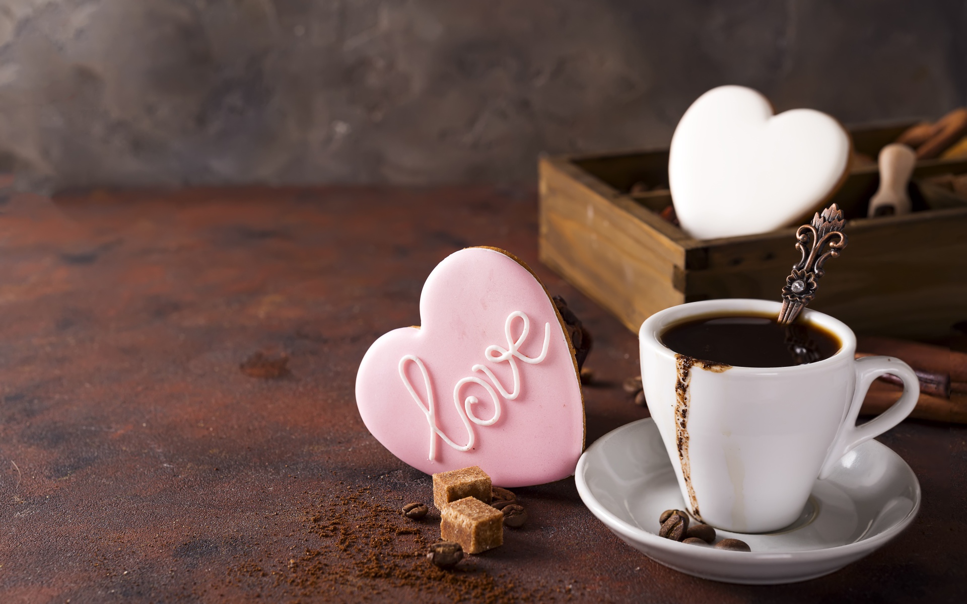 Чашка кофе на столе с сахаром и печеньем в форме сердца 