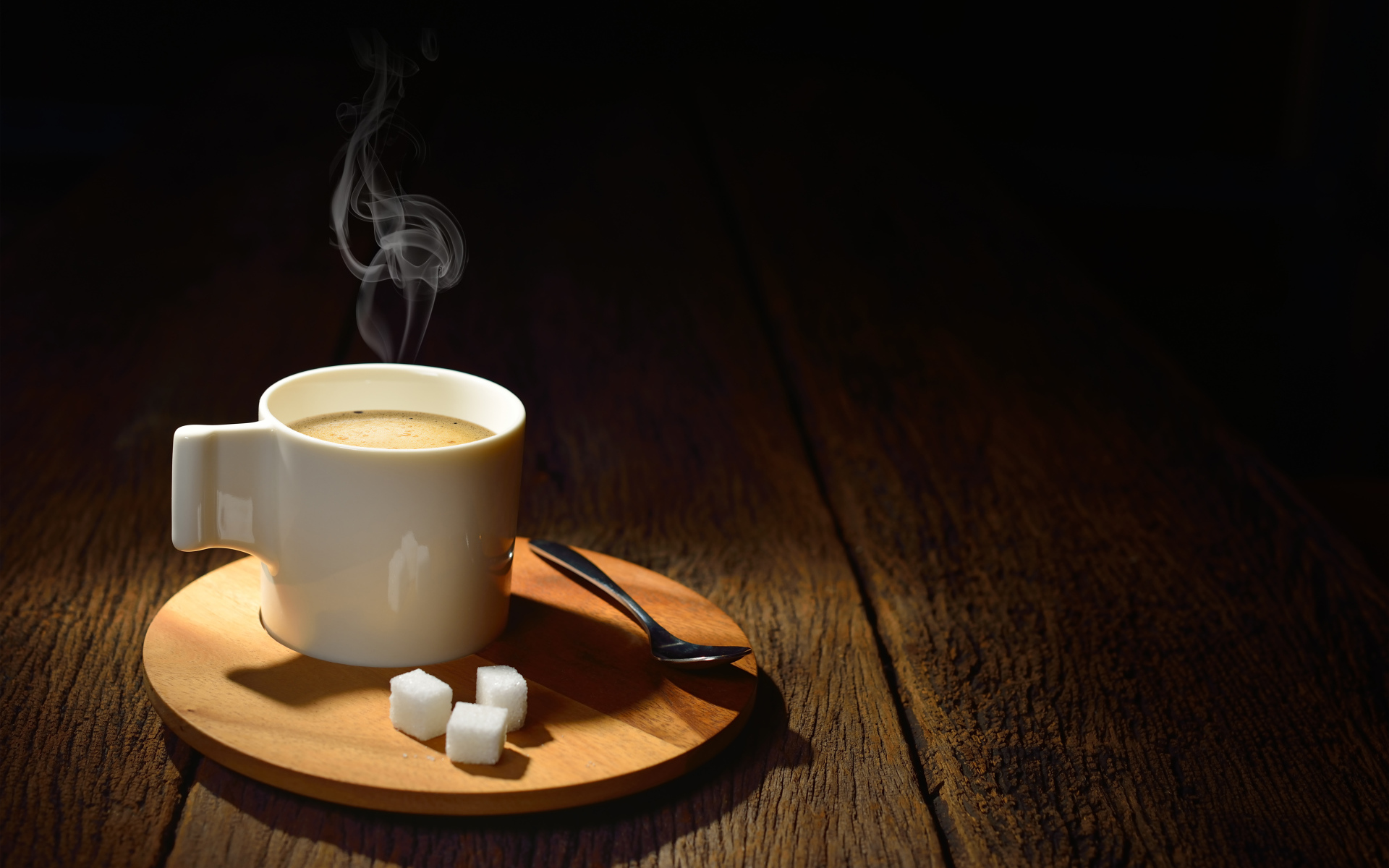 Чашка горячего кофе на столе с сахаром