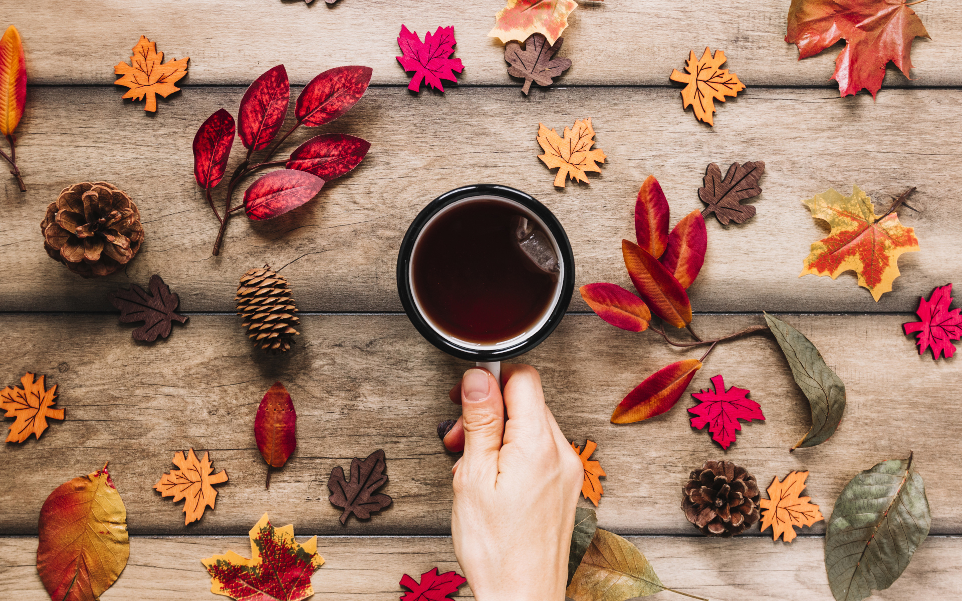 Кружка чая на столе с осенними листьями