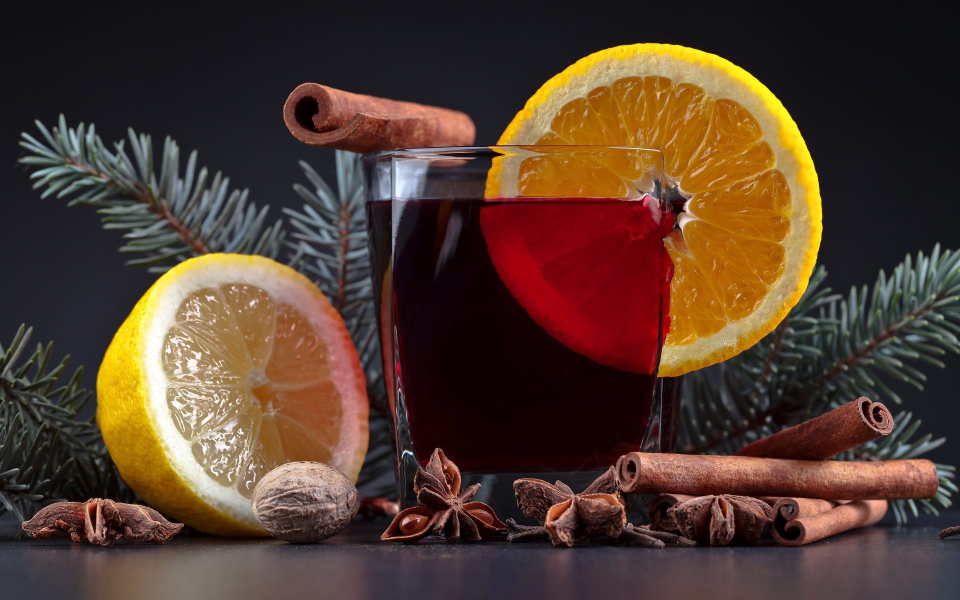 Чай с лимоном, корицей и бадьяном на сером фоне с еловой веткой