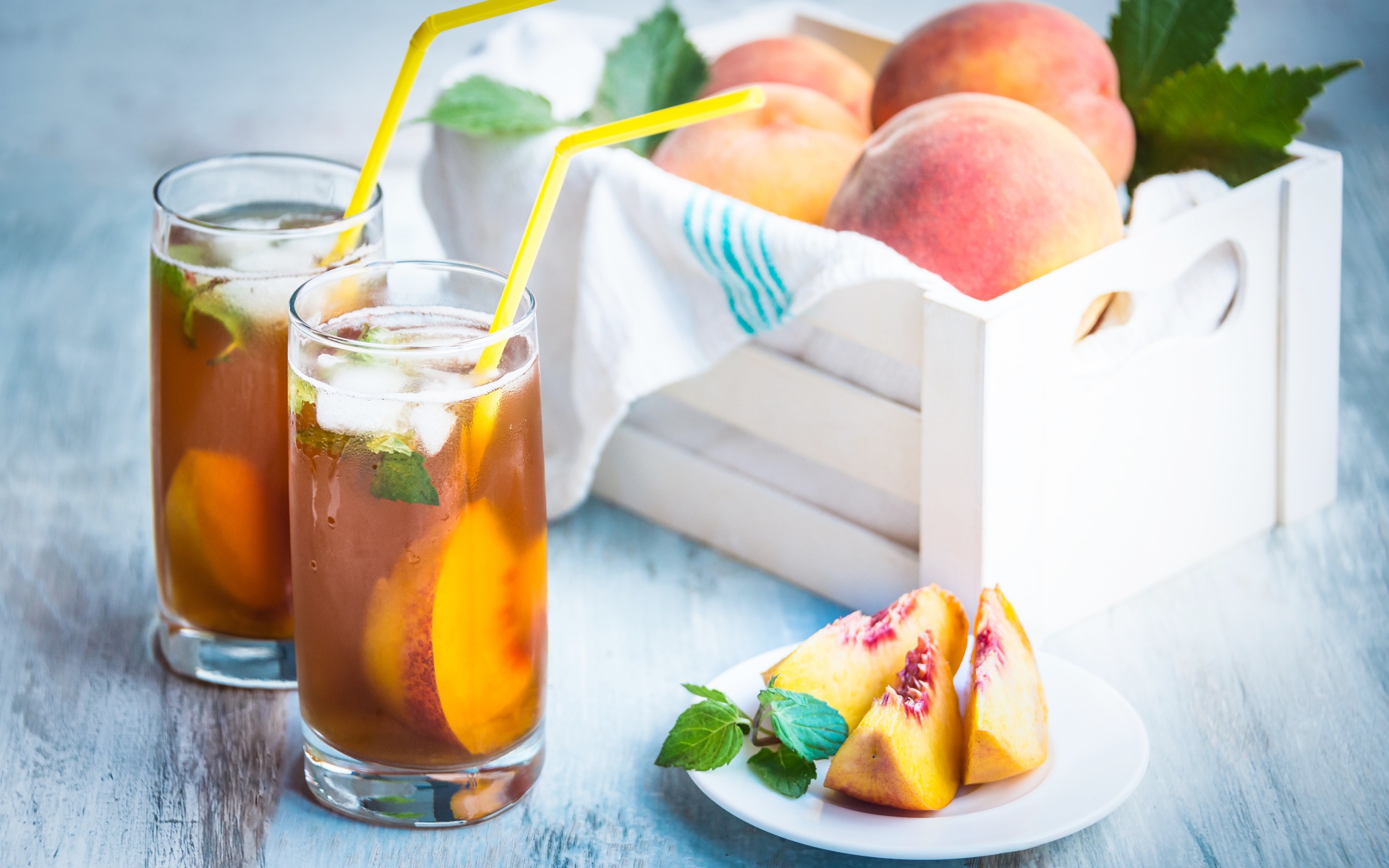Два стакана сока на столе с персиками