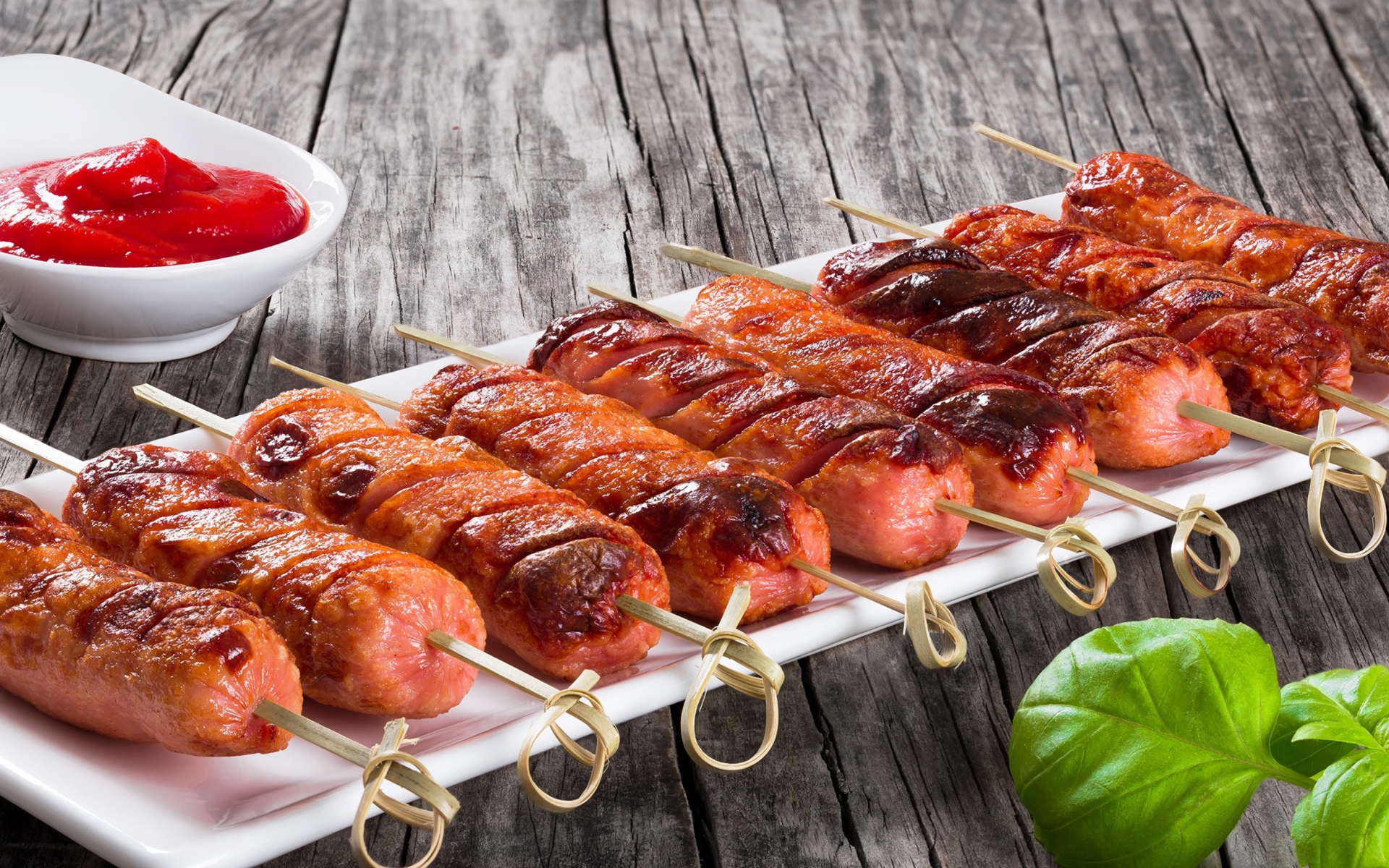 Сосиски гриль на шпажках на столе с соусом