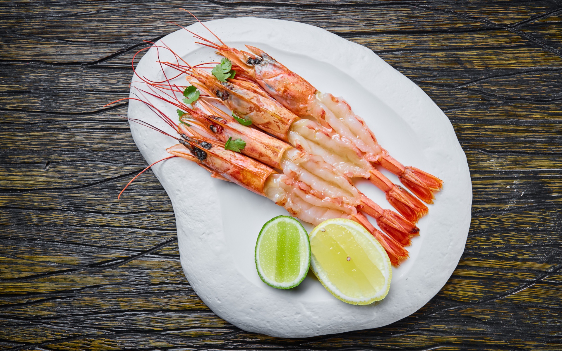 Аппетитные креветки на белой тарелке с лимоном