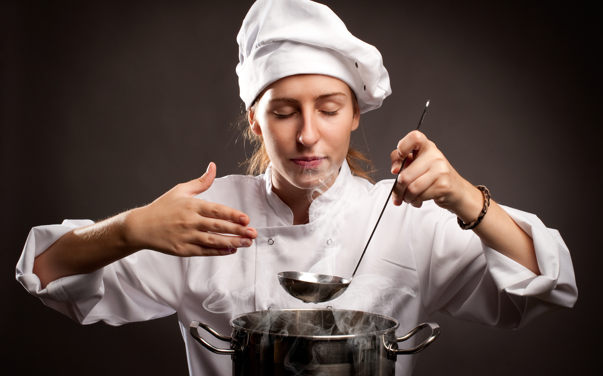 Girl cook inhales the aroma of the dish