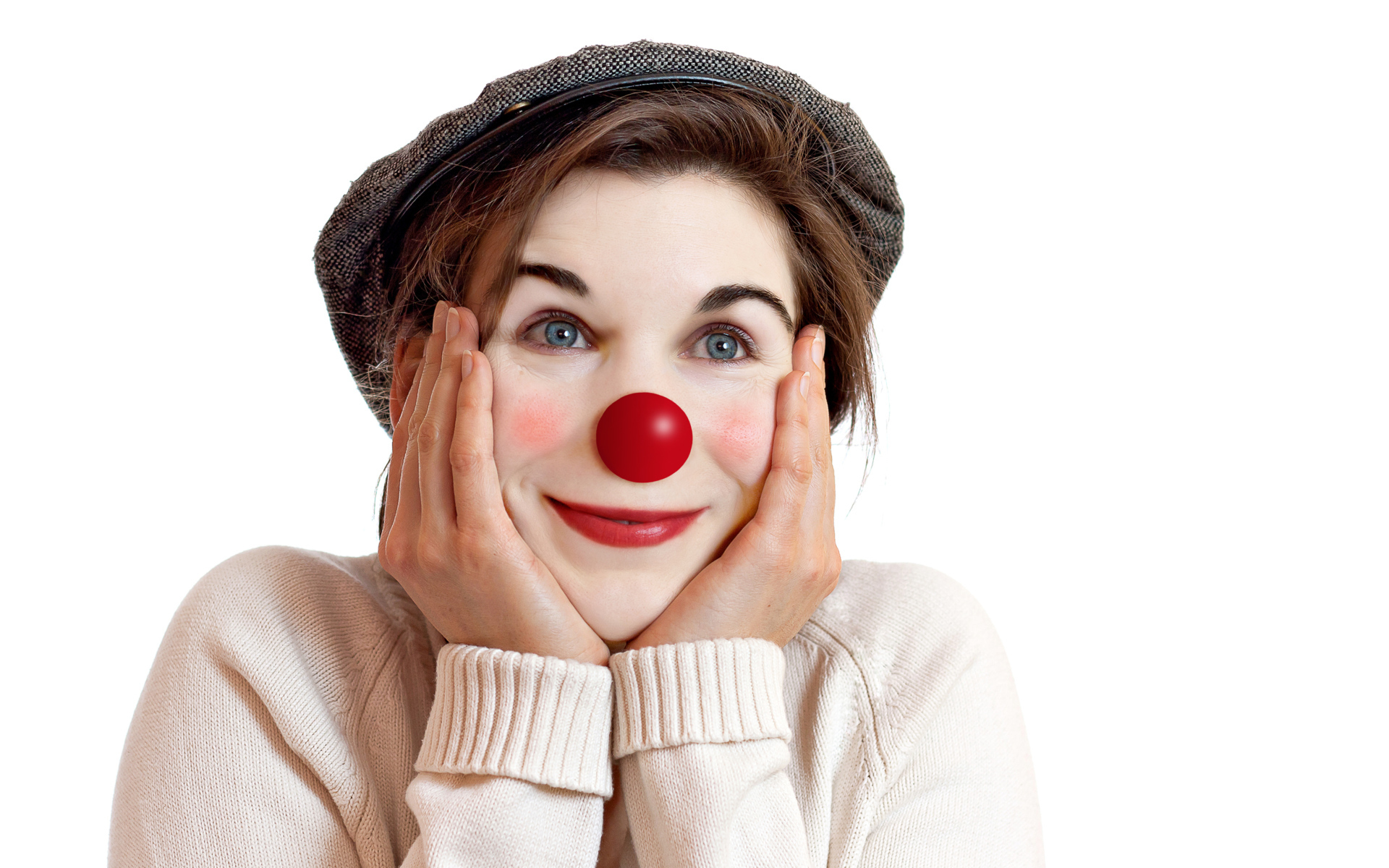 Красивая голубоглазая девушка в кепке с носом клоуна на белом фоне