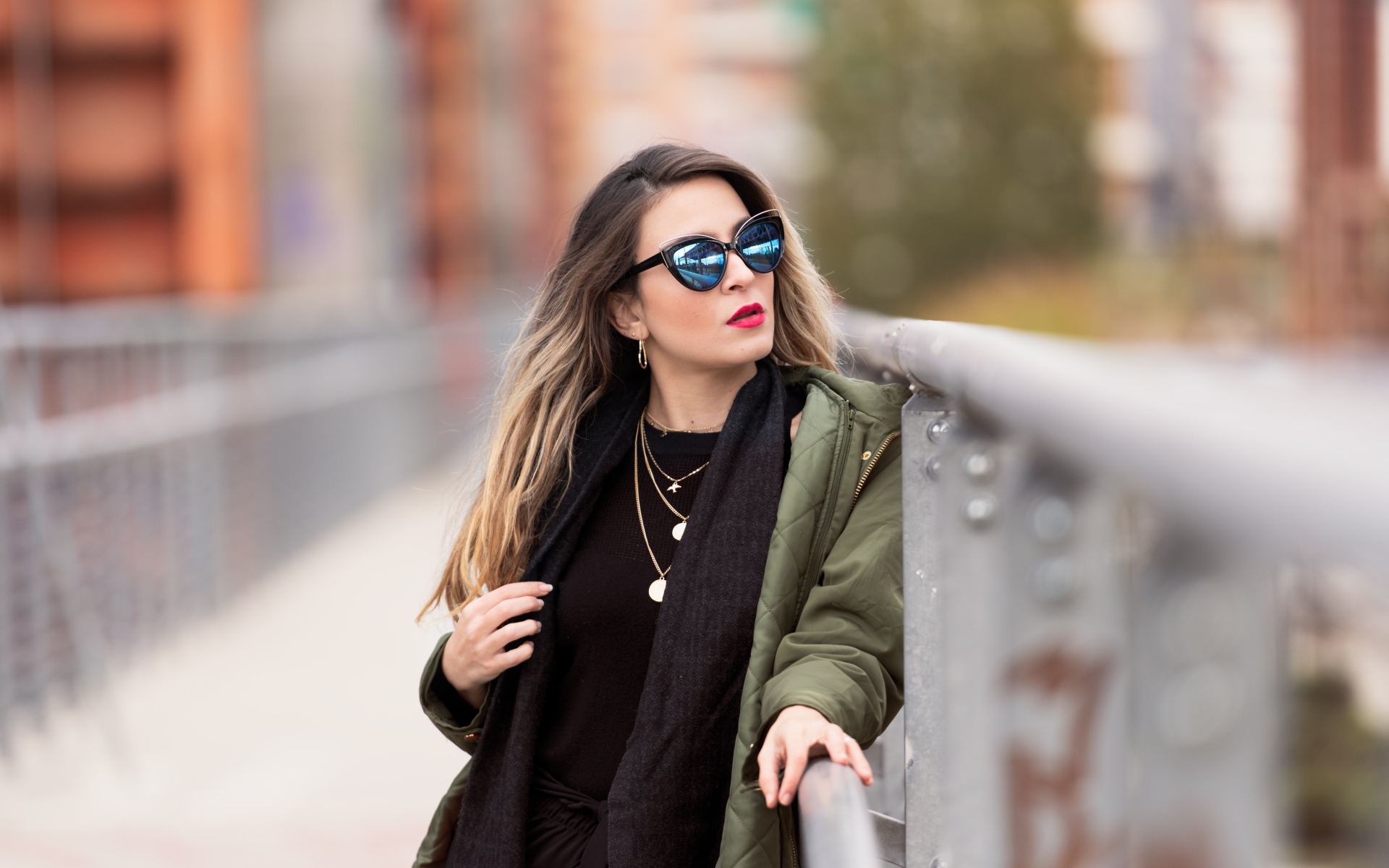 Красивая девушка в солнечных очках на мосту