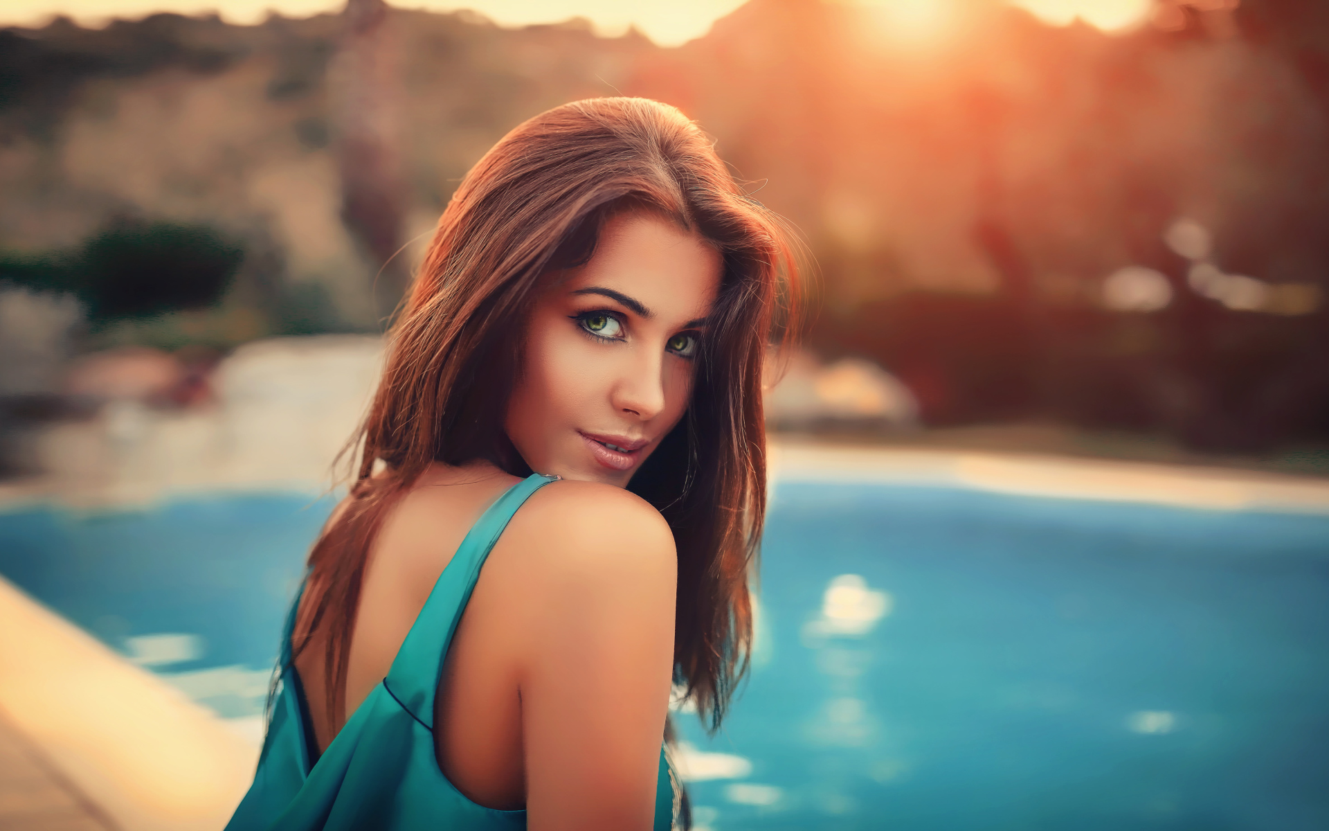 Красивая зеленоглазая шатенка у бассейна