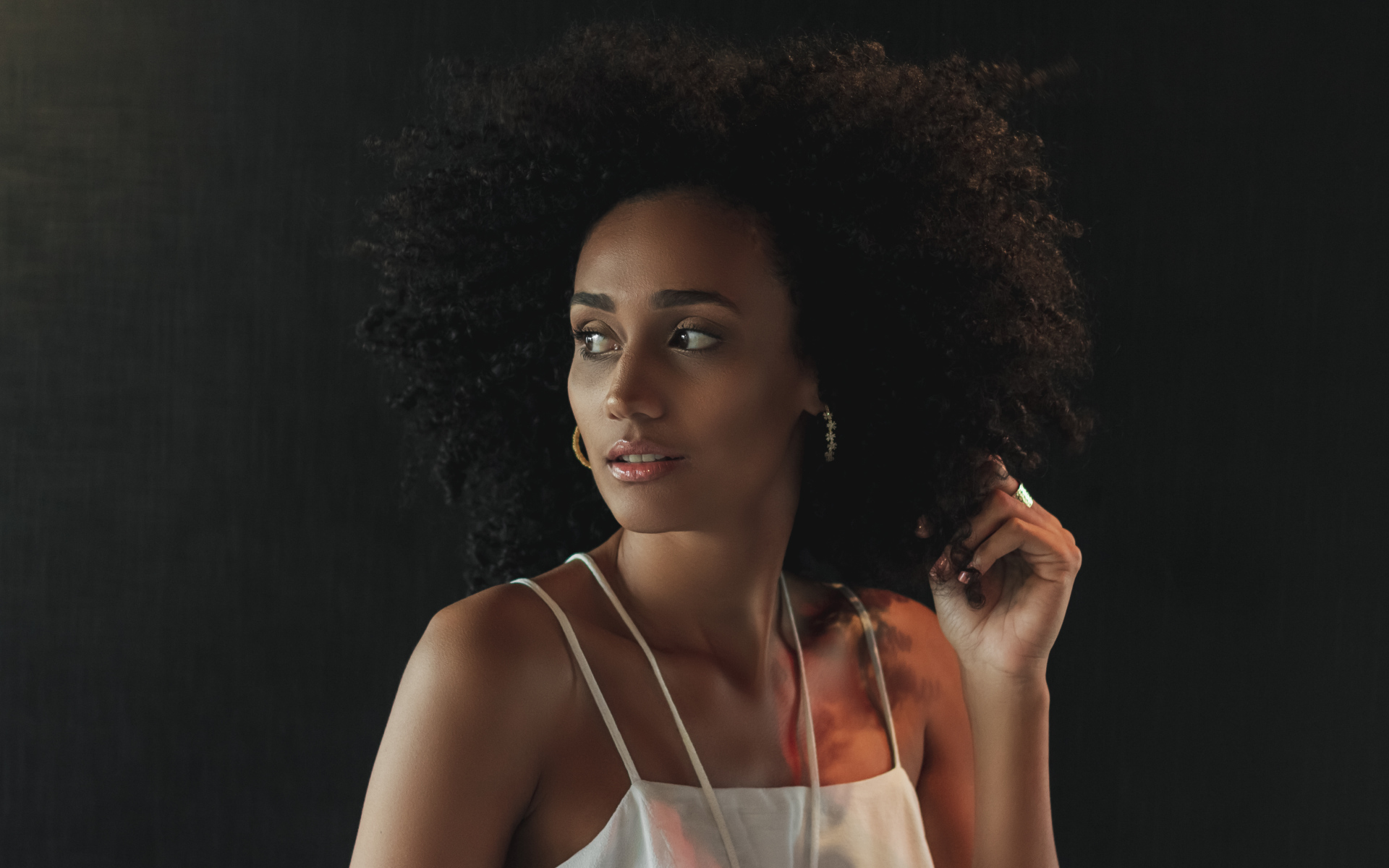 Темнокожая девушка с красивыми волосами на сером фоне