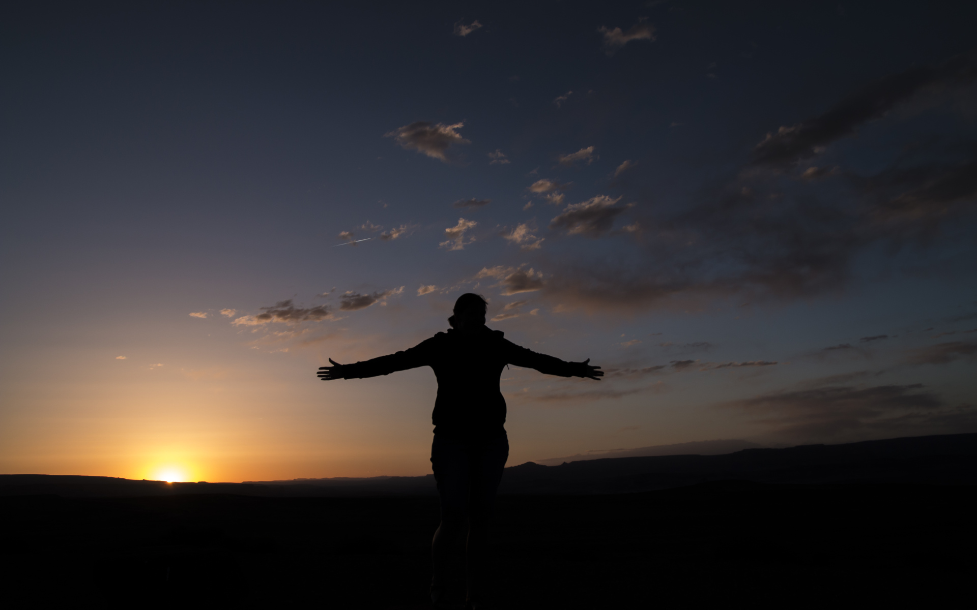 Силуэт девушки на фоне неба на закате