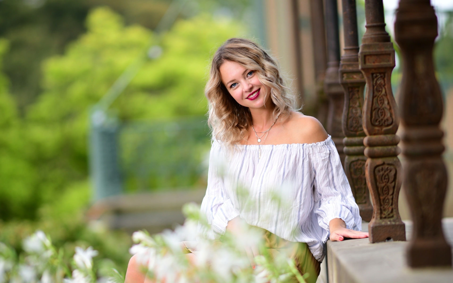 Улыбающаяся девушка сидит на ступенях