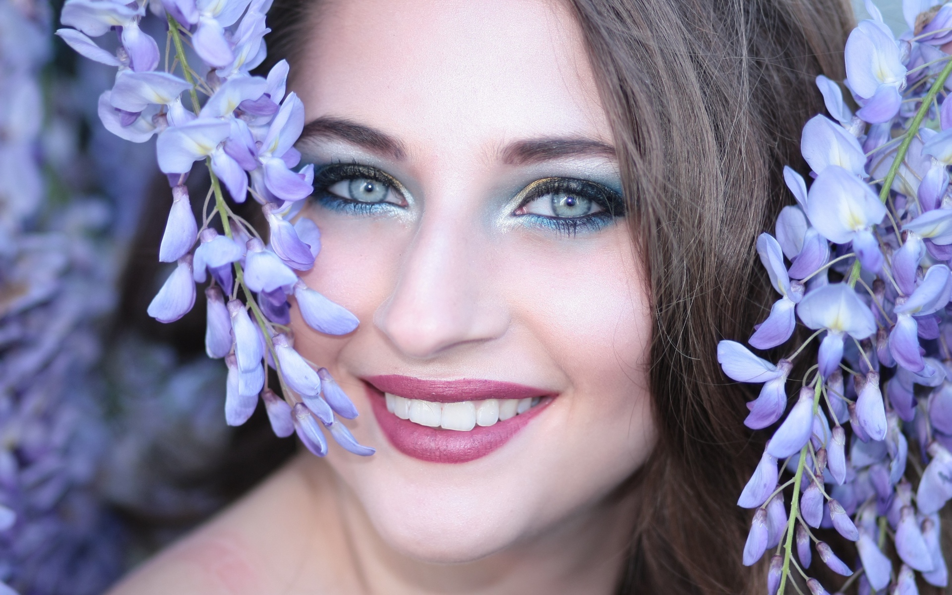 Улыбающаяся девушка с цветами глицинии