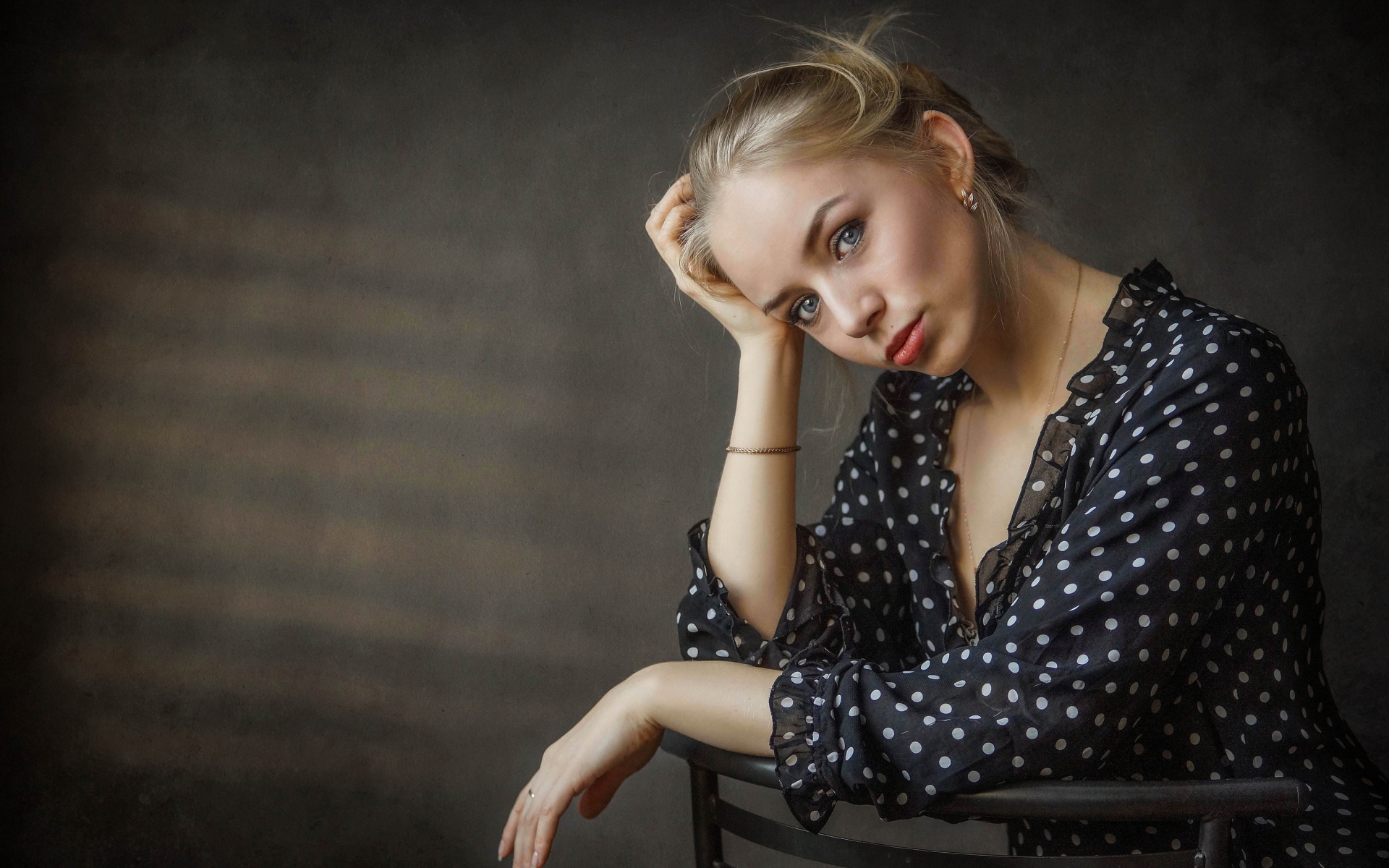 Нежная девушка блондинка сидит на стуле