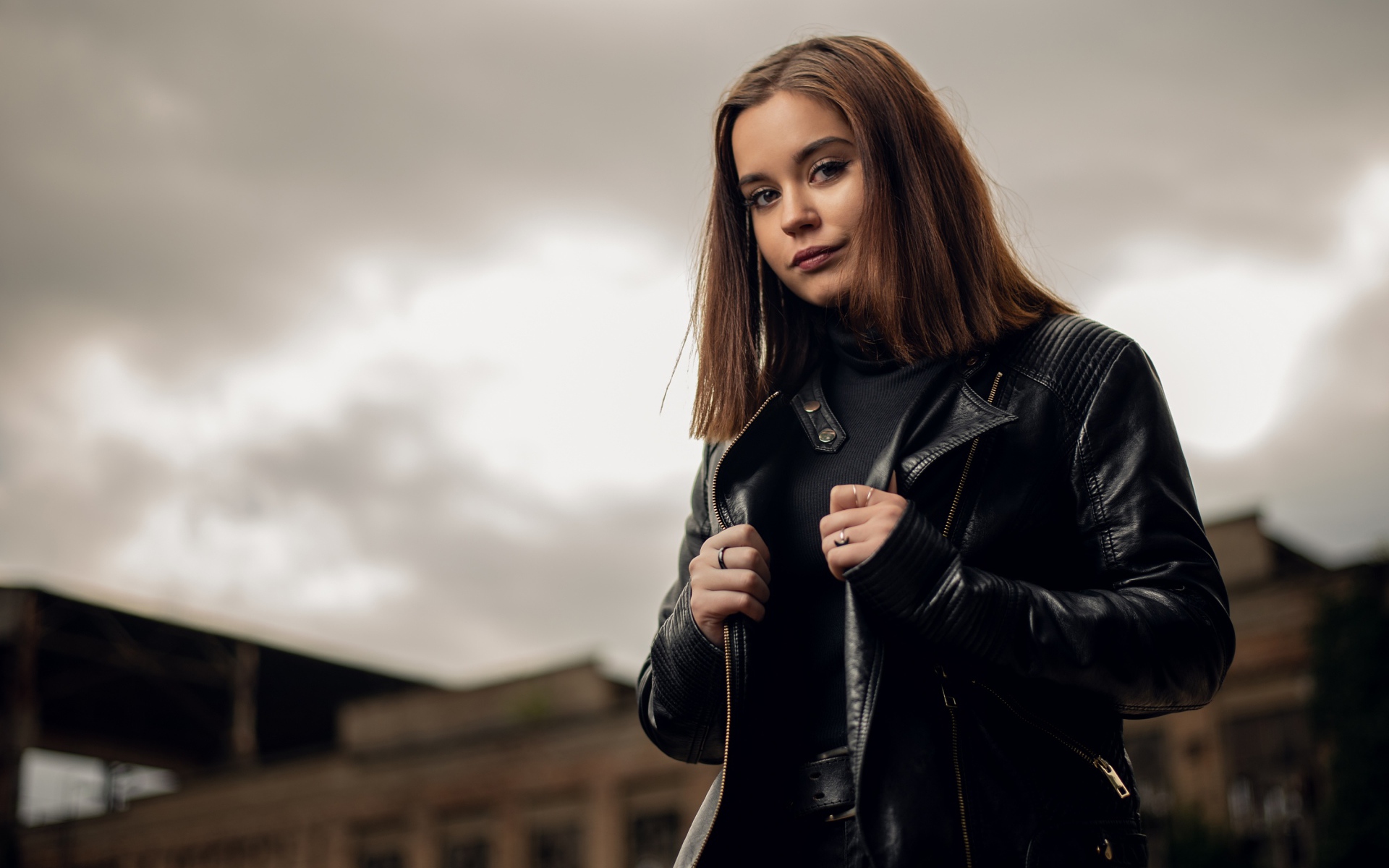 Молодая девушка в кожаной куртке на фоне грозового неба