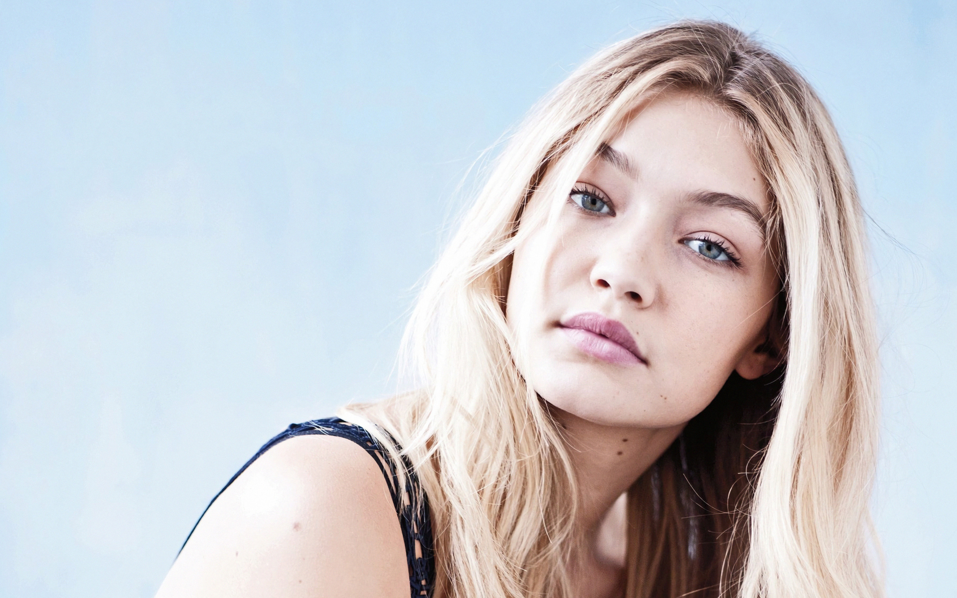 Молодая блондинка, модель Джиджи Хадид на сером фоне