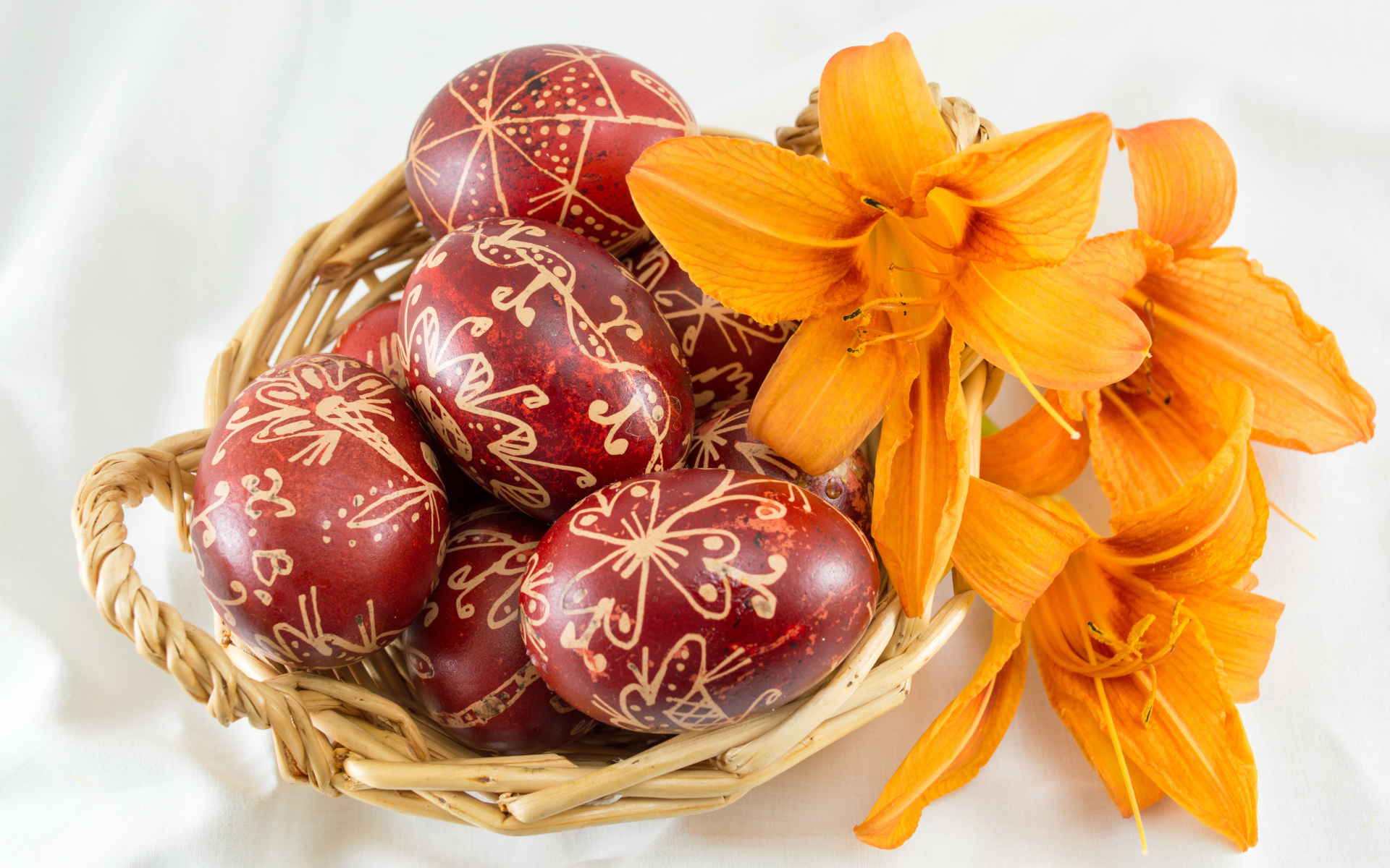 Красивые крашеные пасхальные яйца на белом фоне с цветами лилии