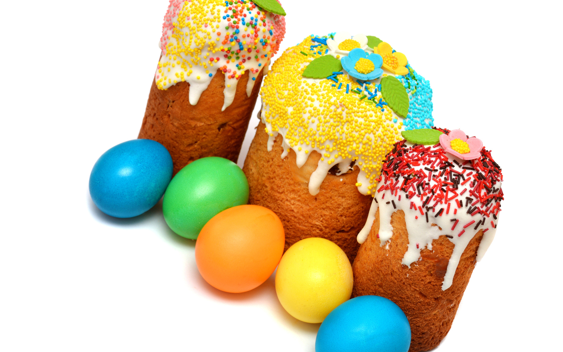 Три кулича с крашеными яйцами на белом фоне к празднику Пасха