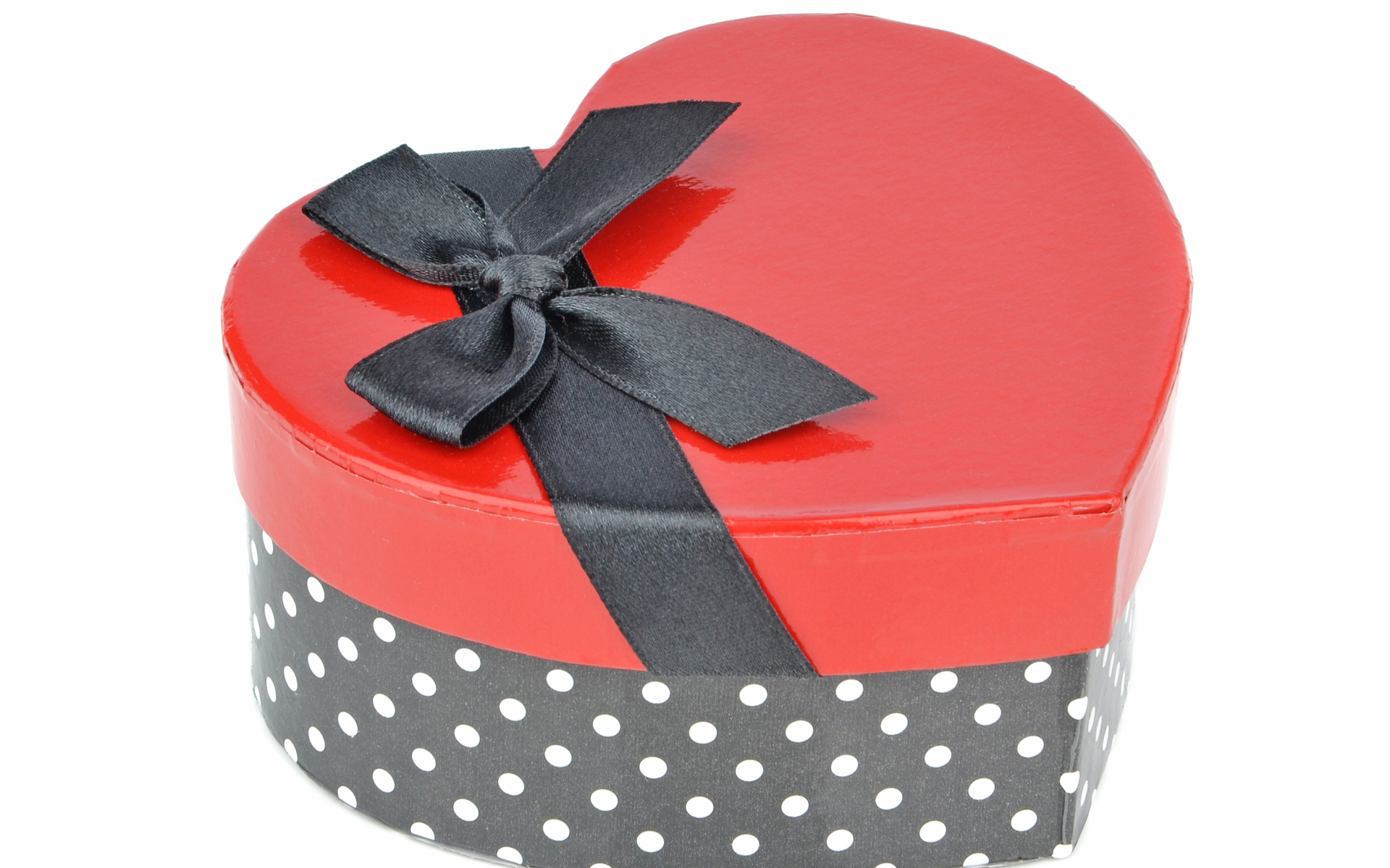 Красивая коробка в форме сердца с черным бантом на белом фоне