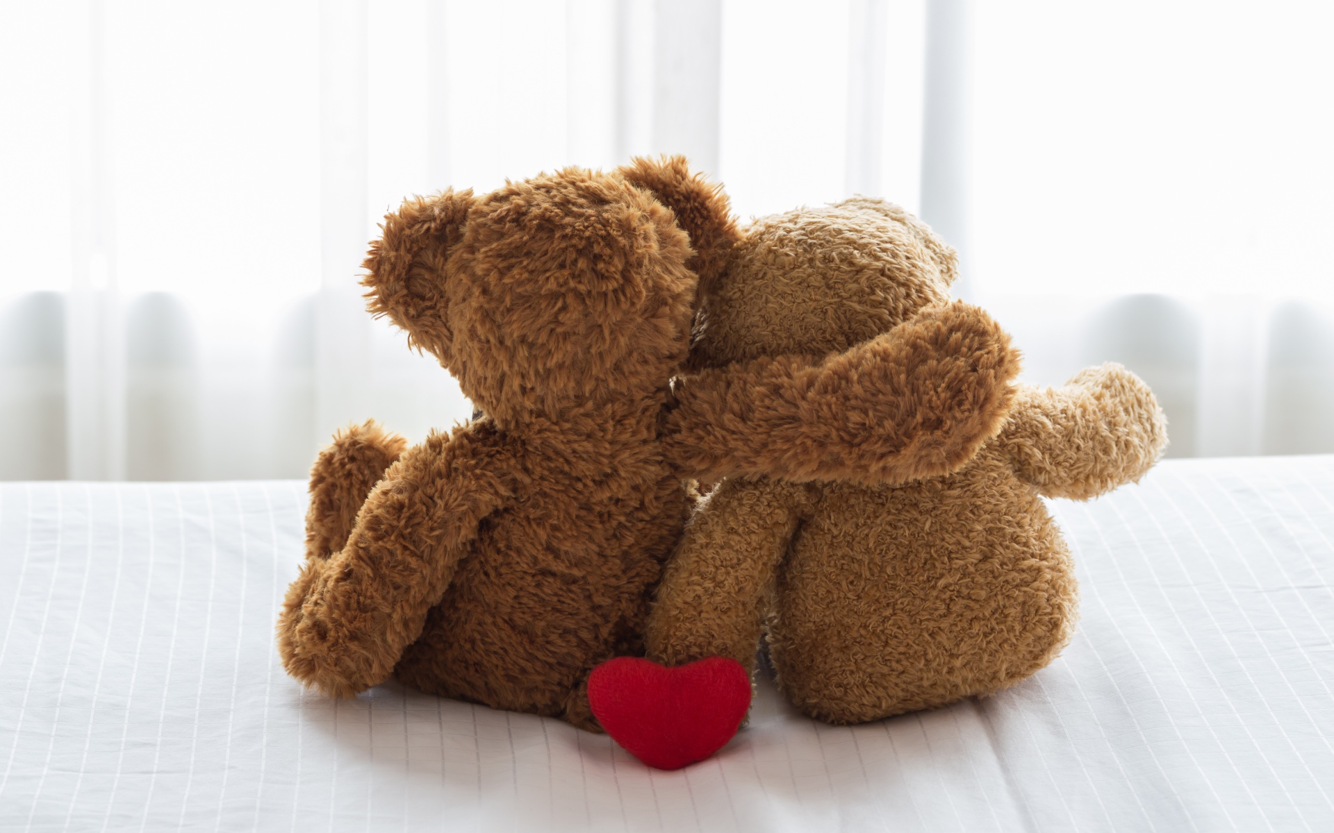 Два влюбленных плюшевых медвежонка на кровати