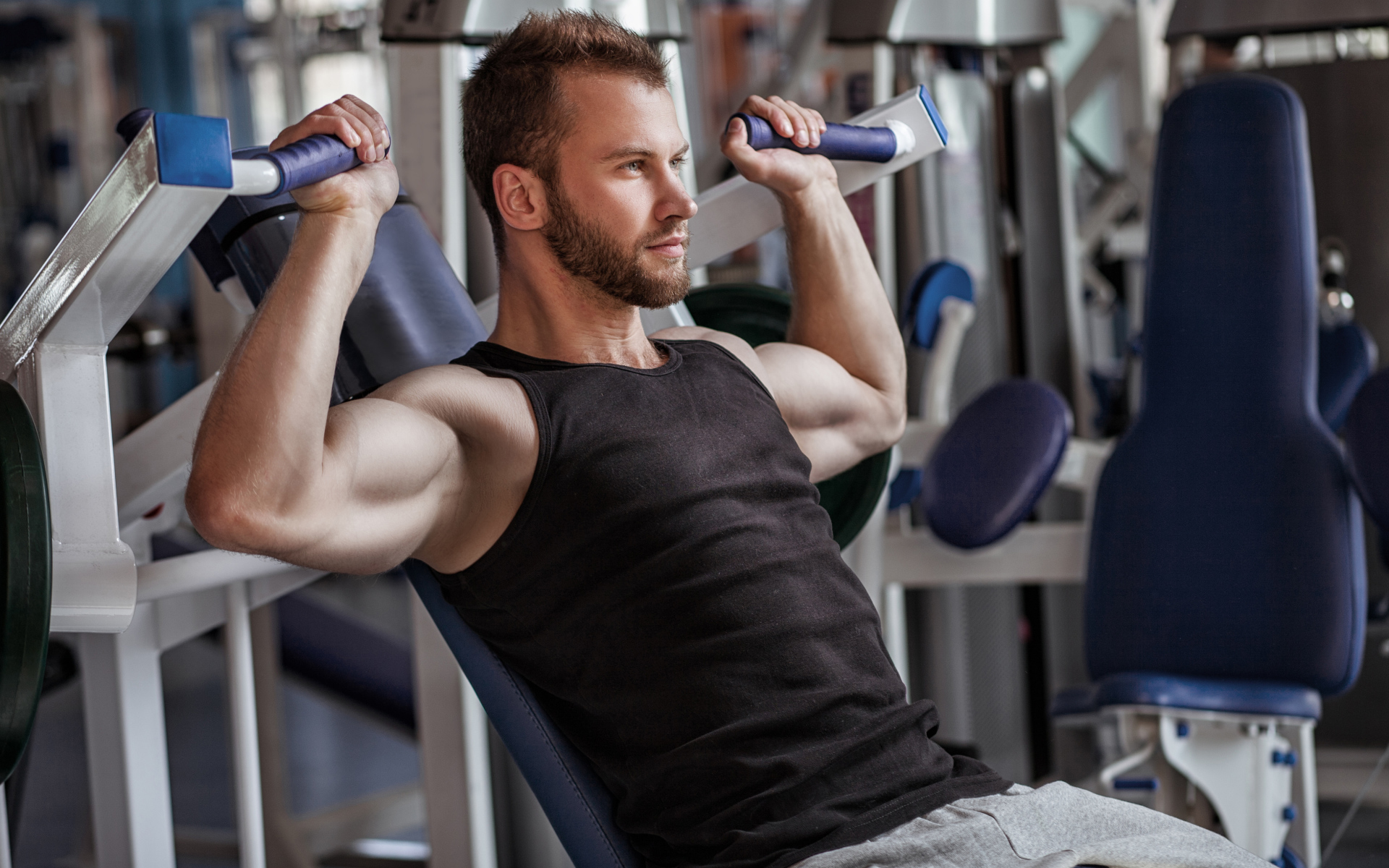 Накаченный мужчина занимается в спортзале