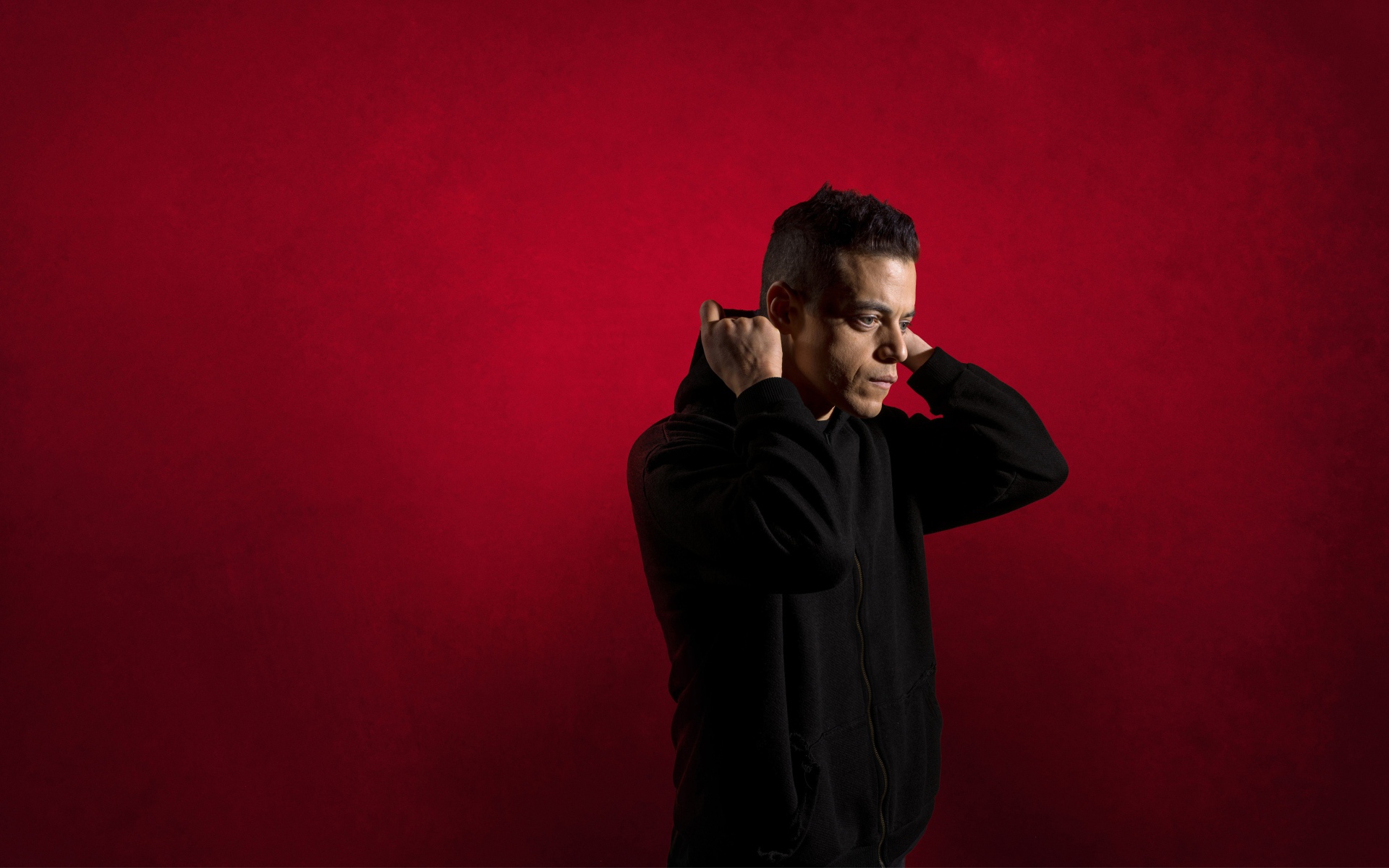 Актер Рами Малек на красном фоне