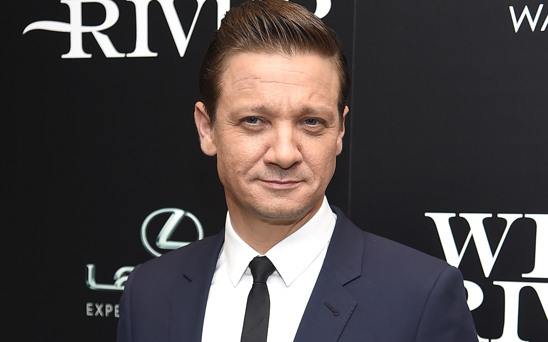 Стильный мужчина в костюме, актер Джереми Реннер