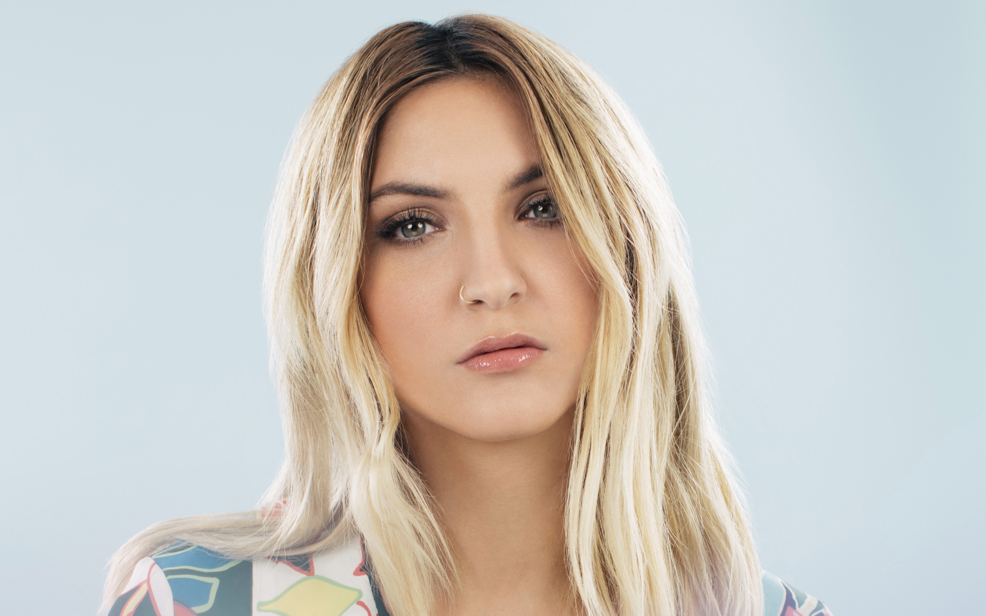 Красивая блондинка, певица Джулия Майклз на сером фоне