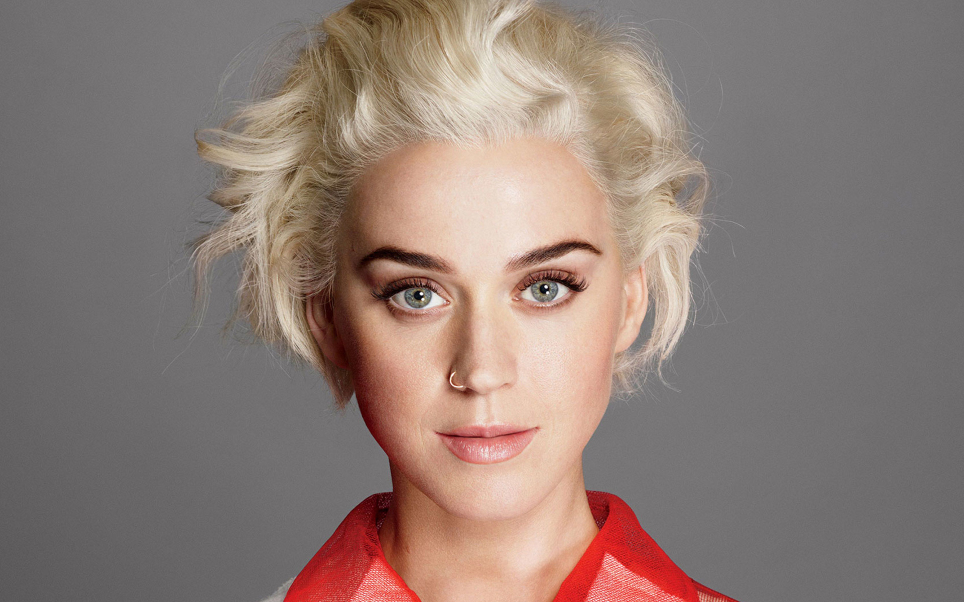 Певица Кэти Перри с короткой стрижкой на сером фоне