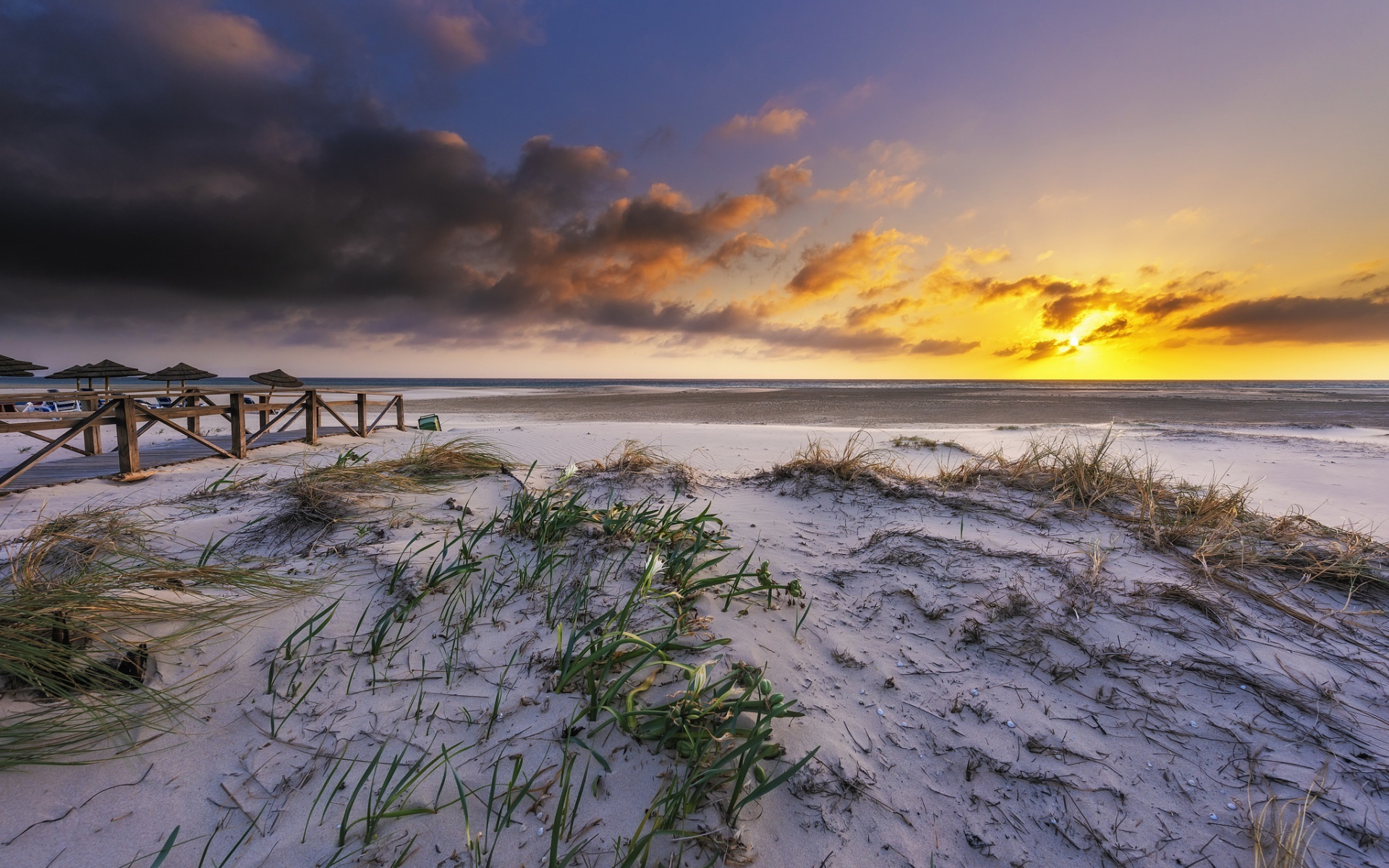 Белый песок в траве на берегу под красивым небом на закате