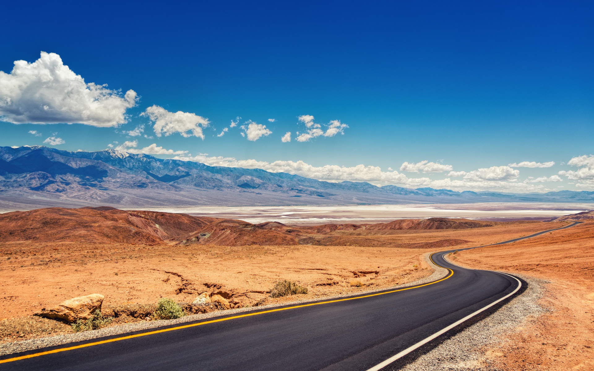 Дорога в пустыне под красивым голубым небом с белыми облаками