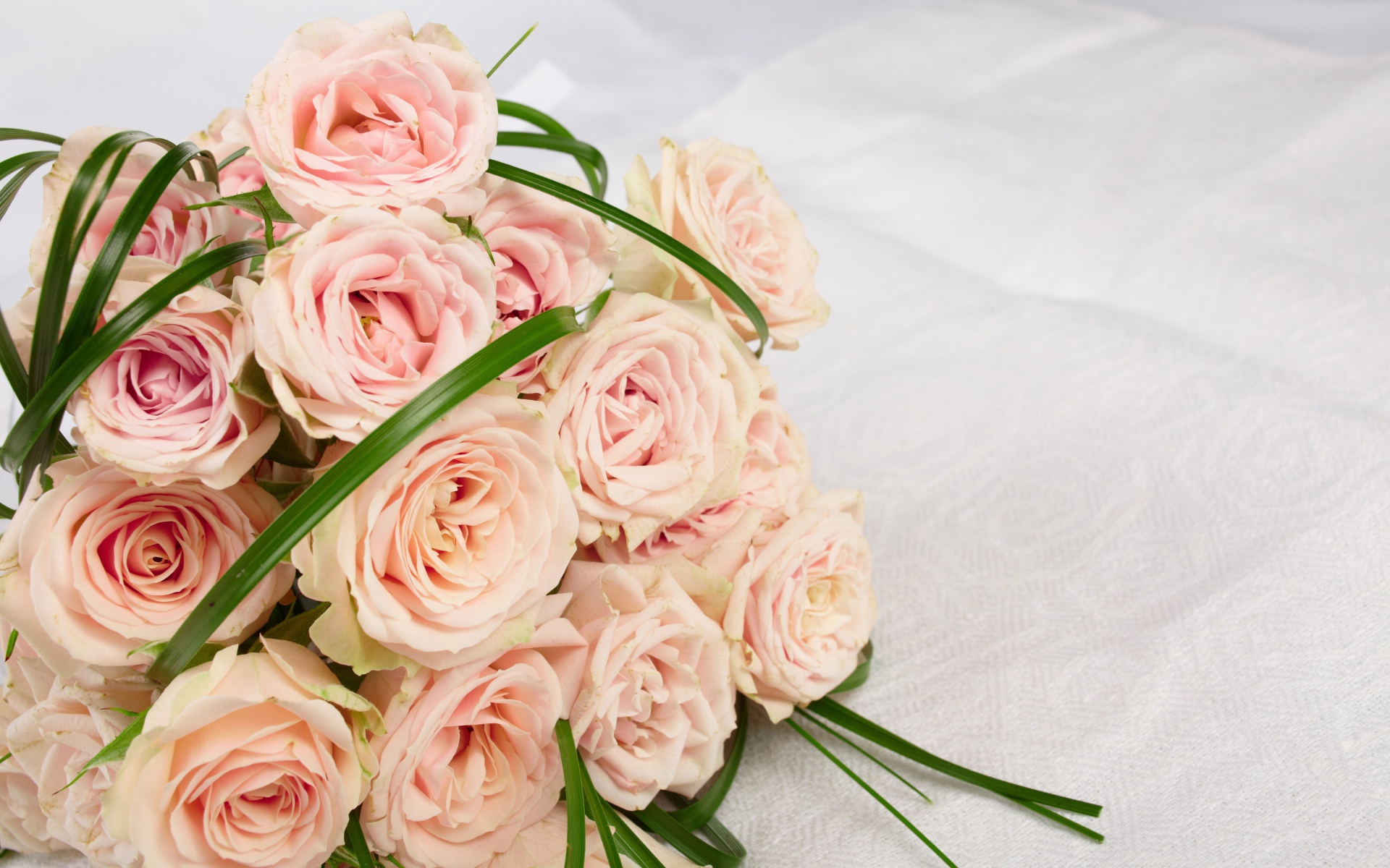 Букет розовых роз на белом покрывале 