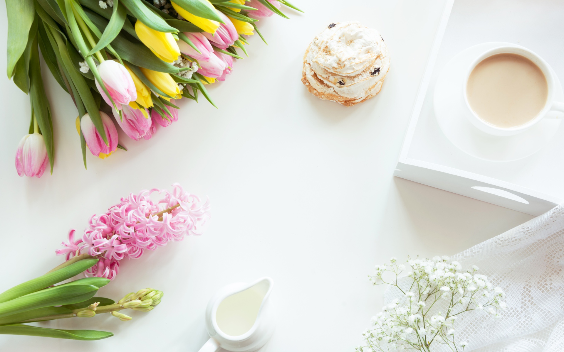 Букет тюльпанов и гиацинт на столе с пирожным и чашкой какао 