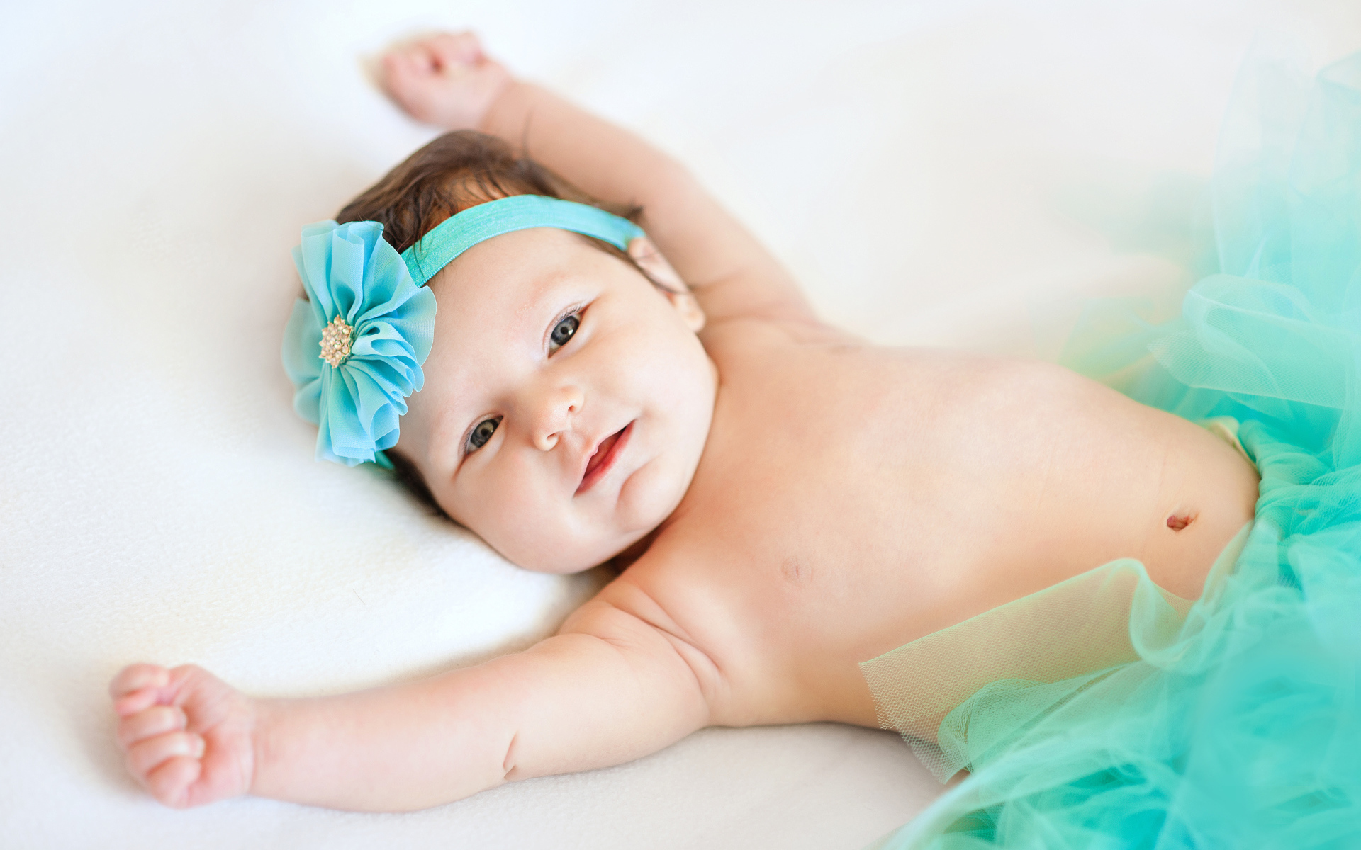 Милая маленькая девочка с повязкой с голубым цветком