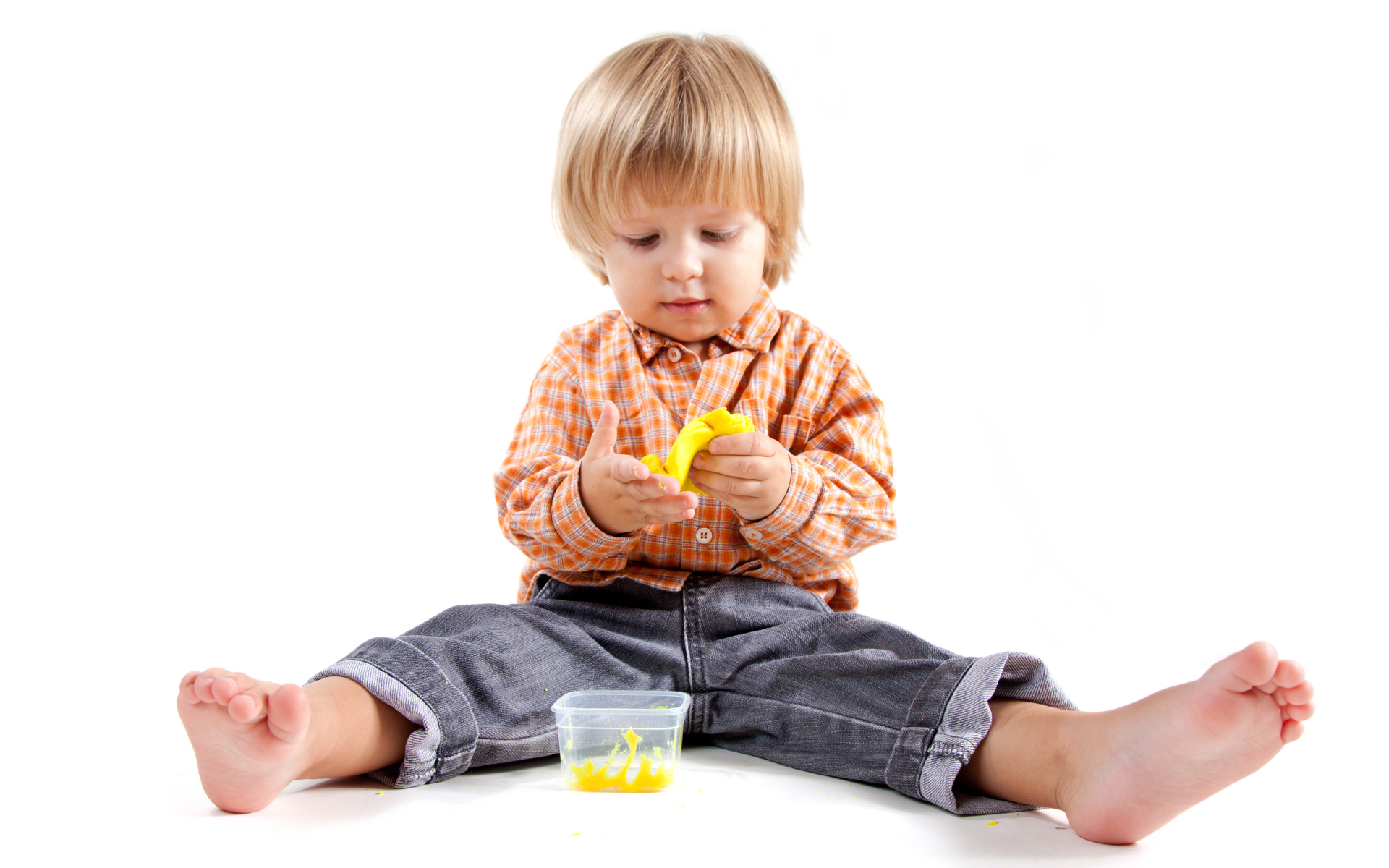 Маленький мальчик с игрушкой на белом фоне