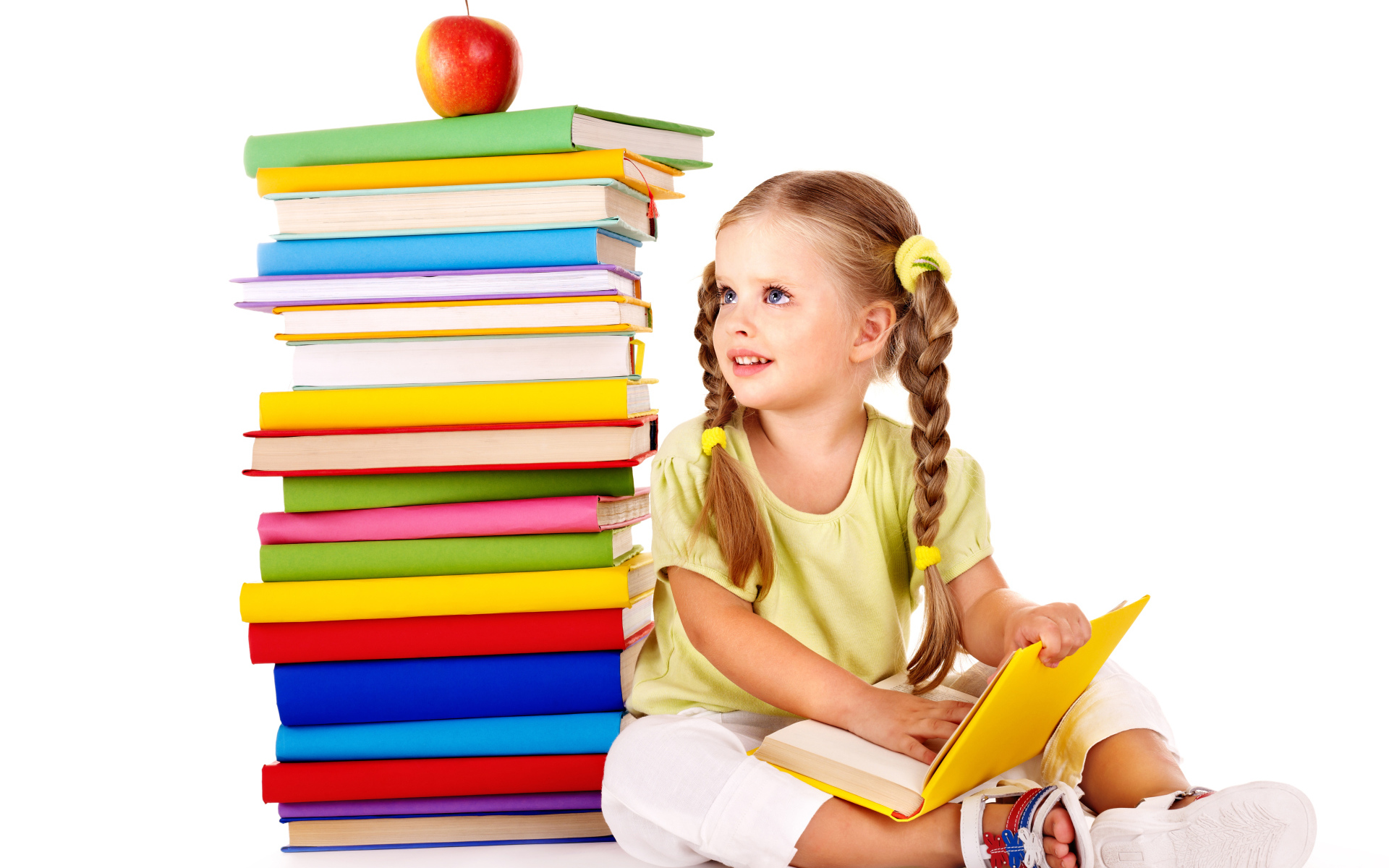Маленькая девочка школьница с книгами на белом фоне