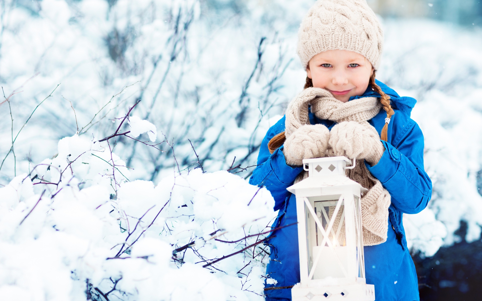 Маленькая девочка с фонарем на улице зимой