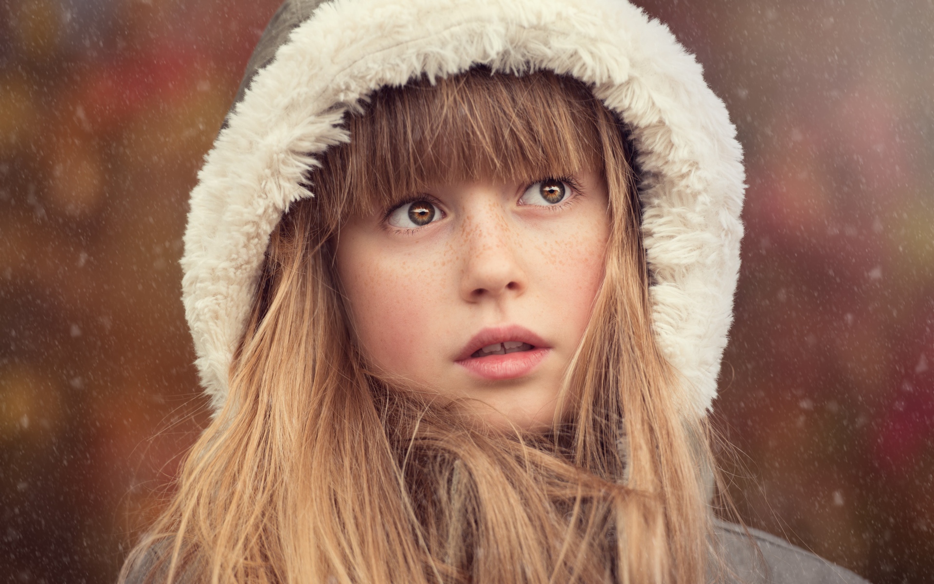 Маленькая девочка с веснушками на лице в капюшоне 