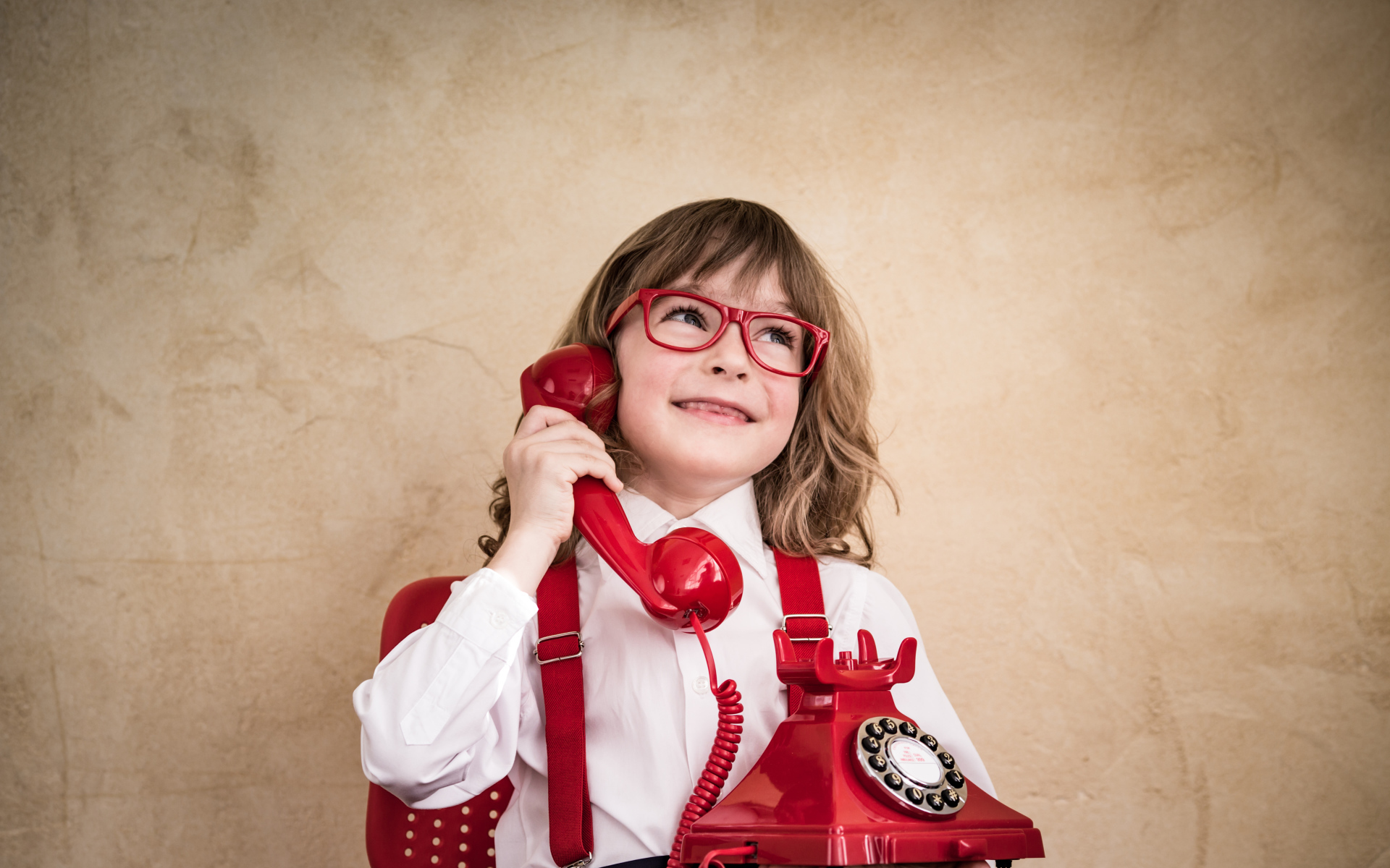 Улыбающийся мальчик с красным телефоном