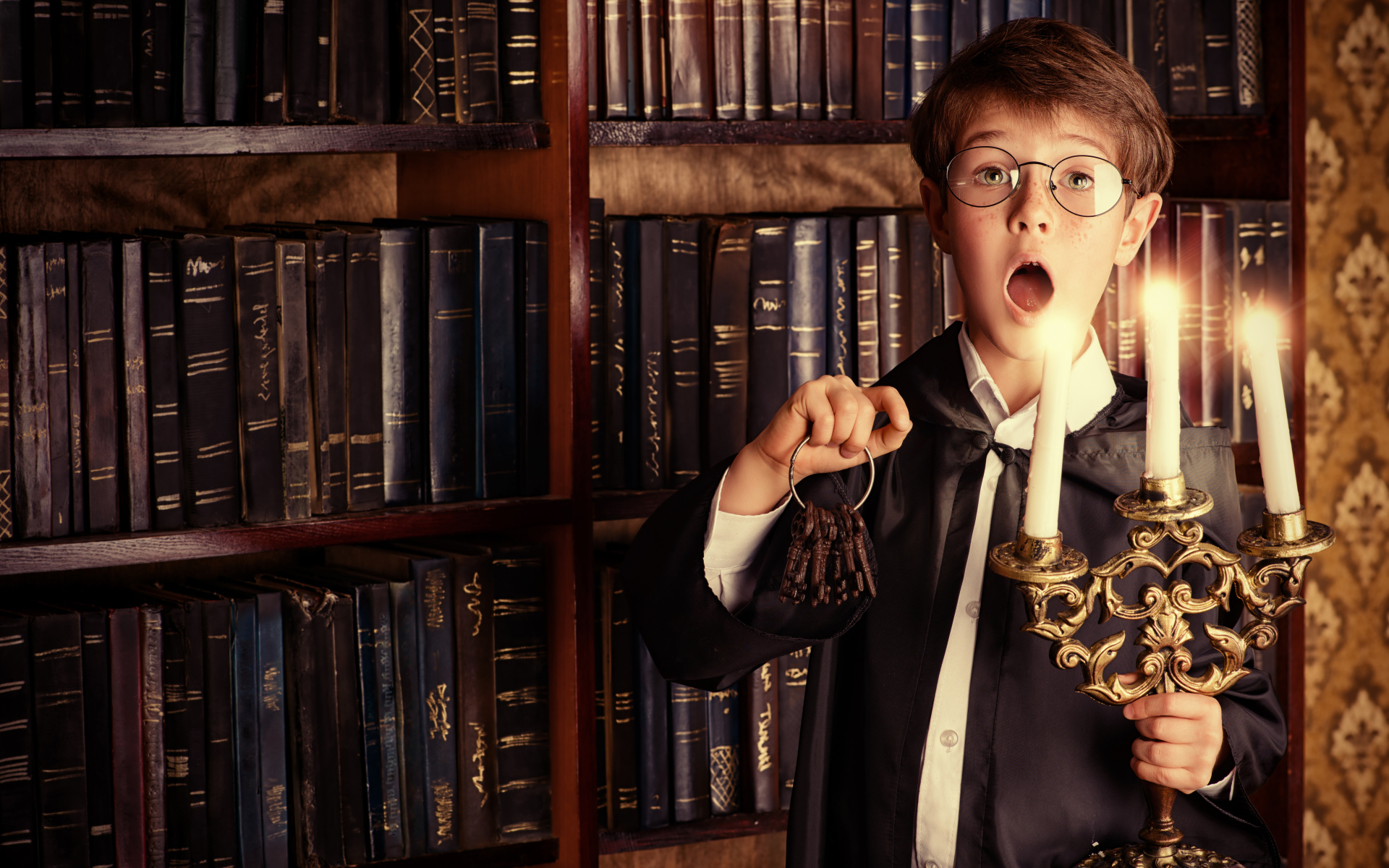 Удивленный мальчик с подсвечником со свечами в библиотеке