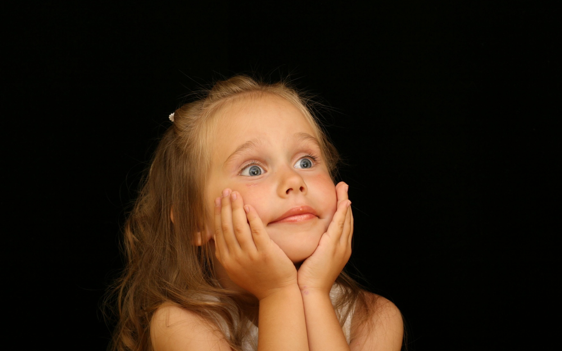 Удивленная маленькая девочка на черном фоне