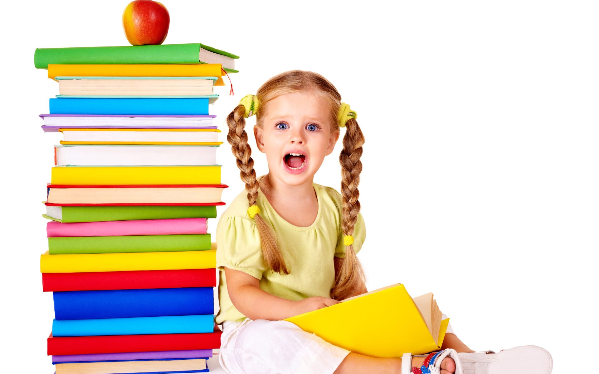  Удивленная маленькая девочка с книгами на белом фоне