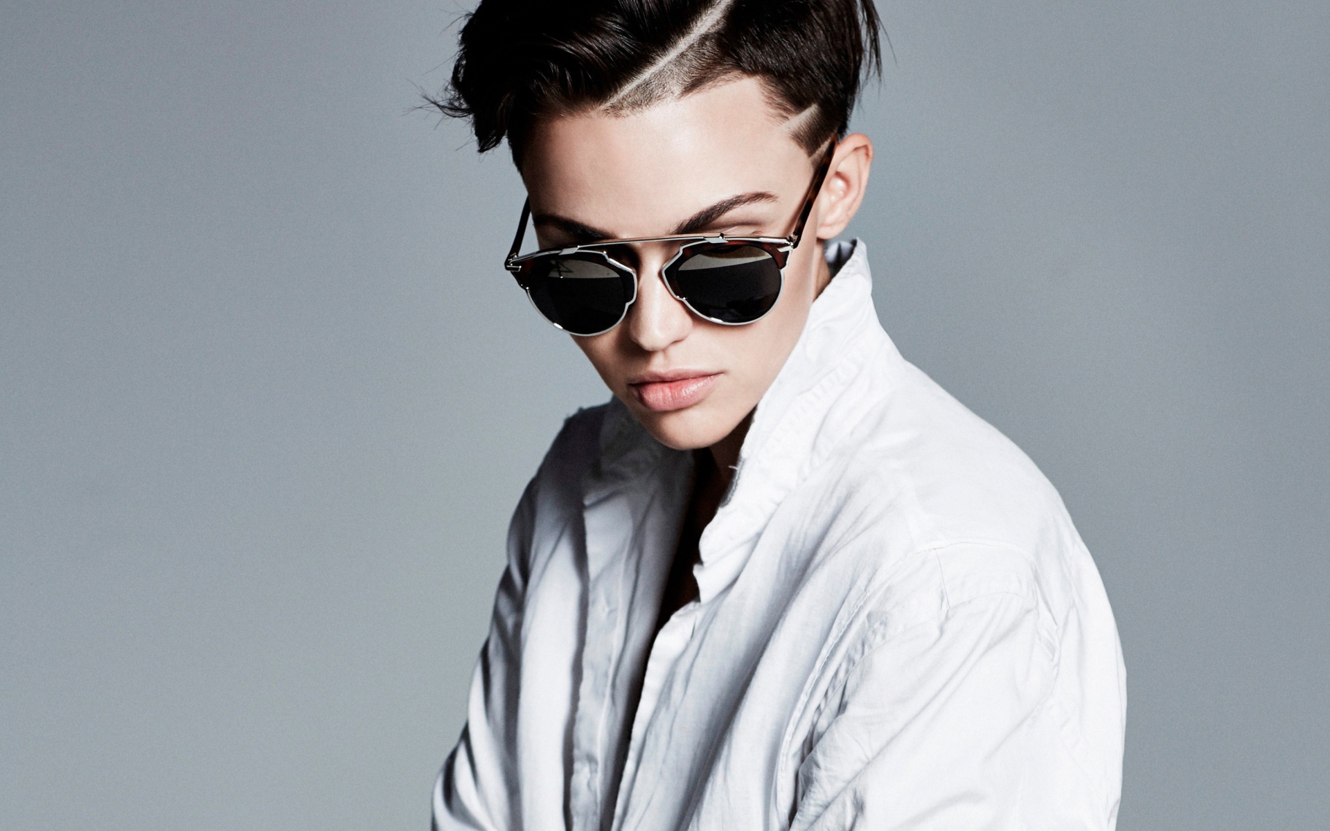 Актриса Руби Роуз в белой рубашке и очках на сером фоне