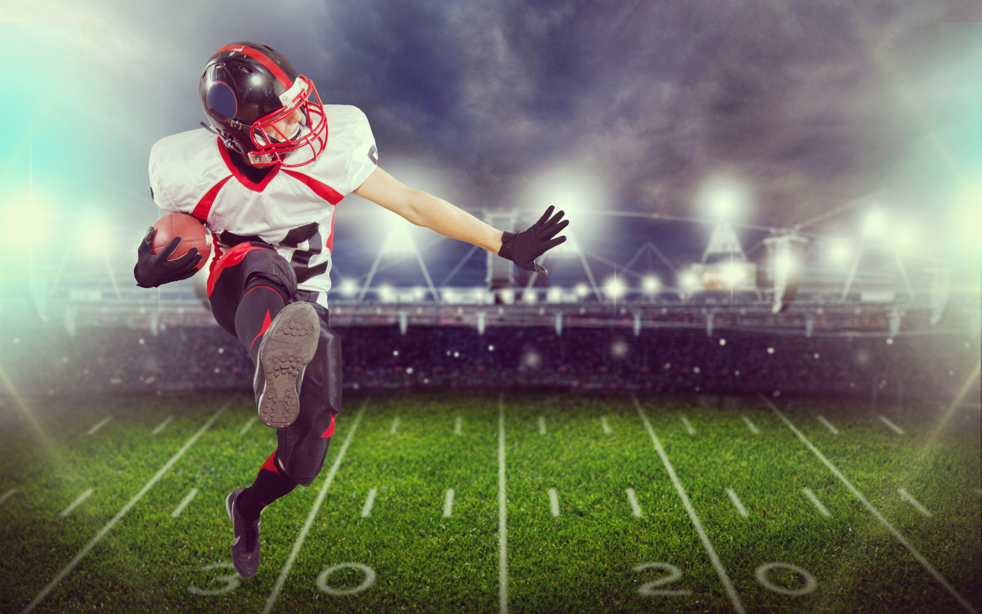 Игрок в американский футбол с мячом на поле