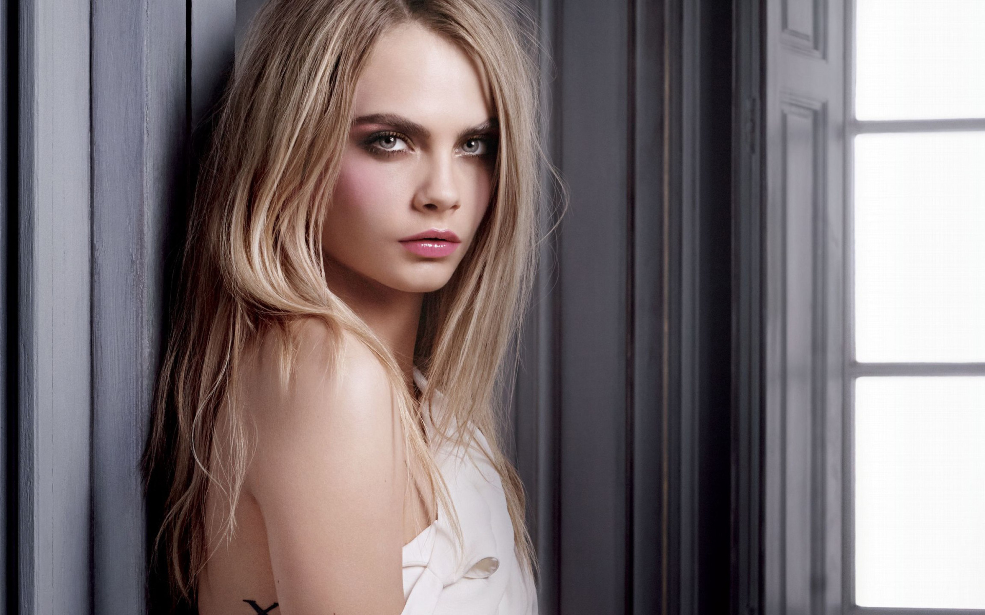 Красивая девушка, актриса Кара Делевинь у стены