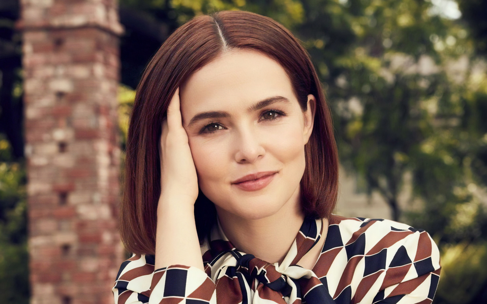 Красивая девушка актриса Зои Дойч с рукой у лица